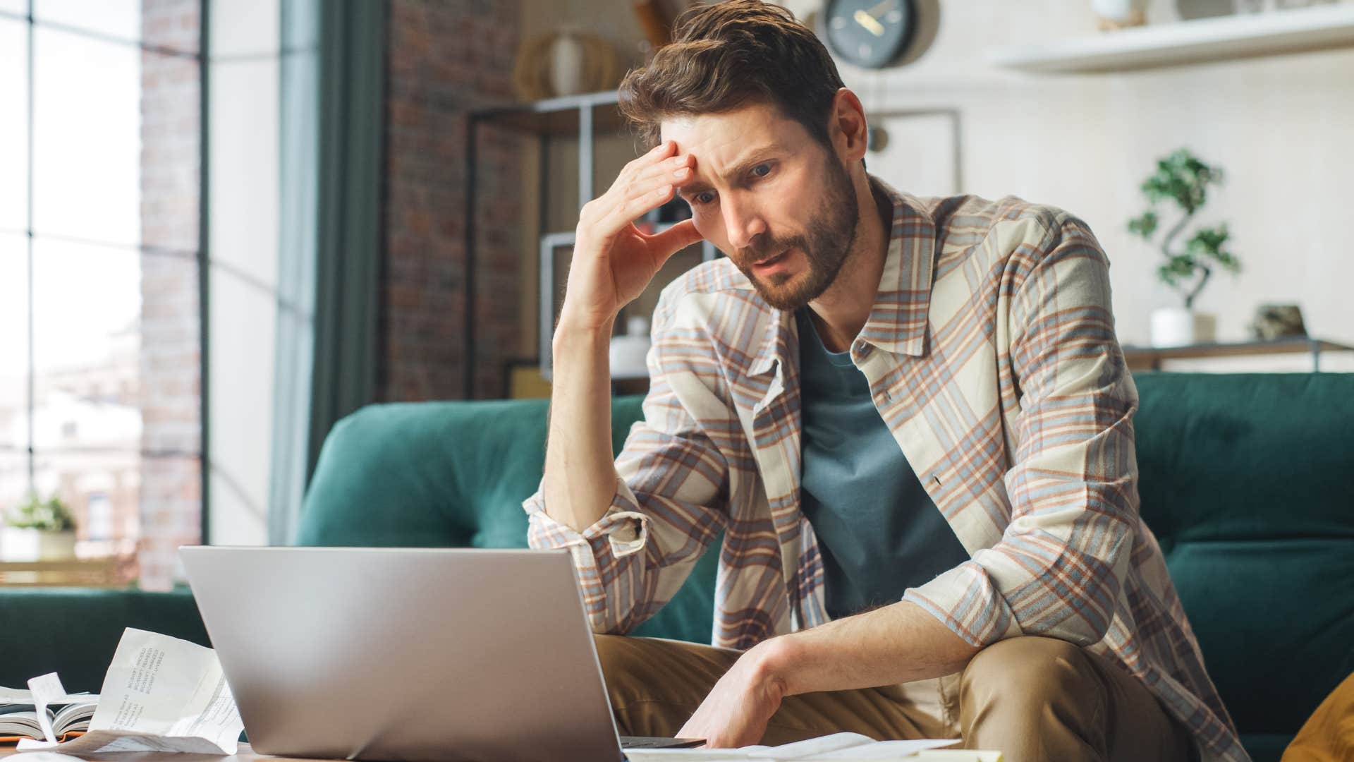 Man struggling with student loans doing bills.