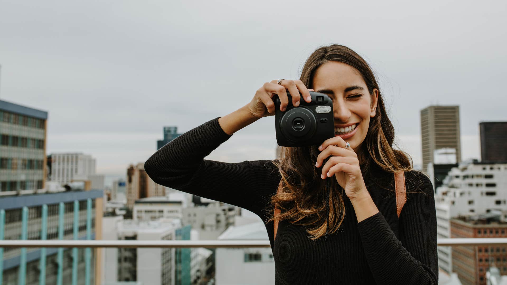 a woman takes photos with a camera that she needs to print later