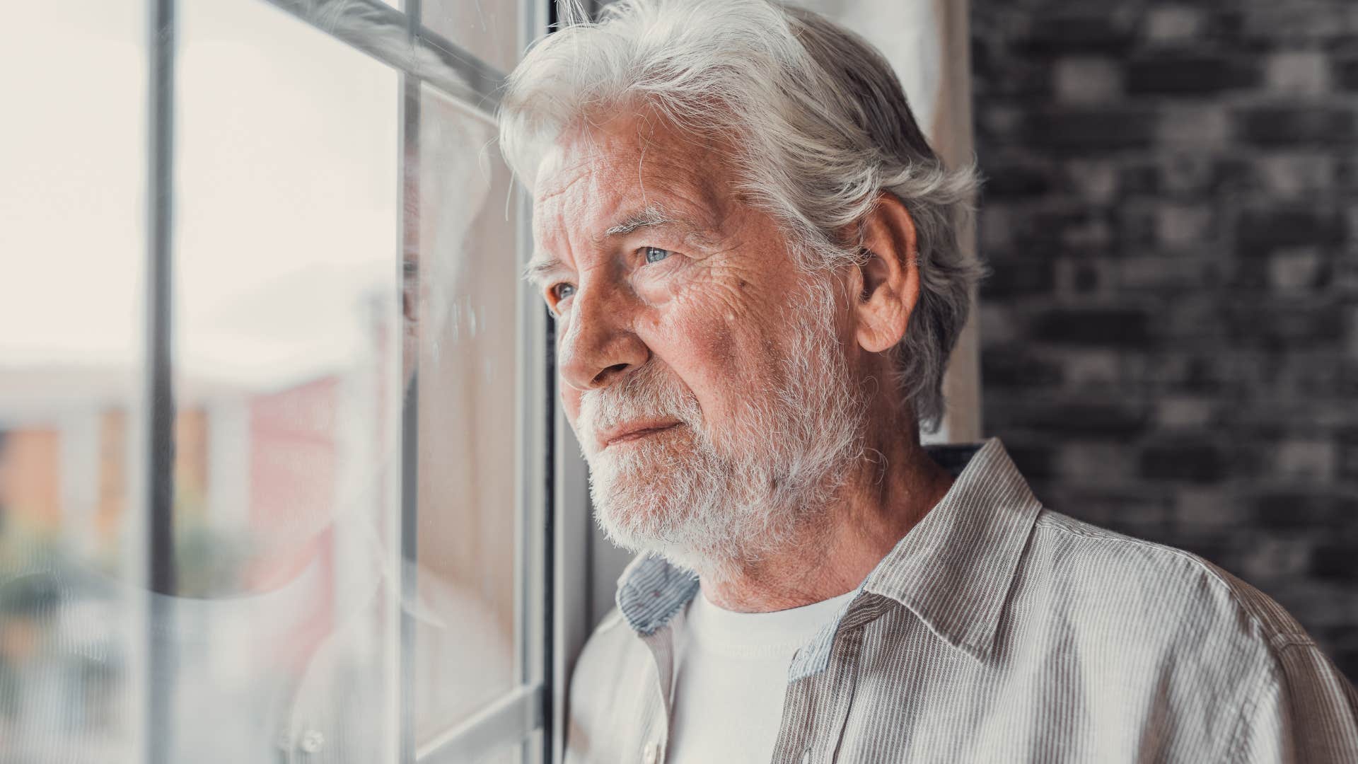 Man who blames others for their mistakes looking out a window.