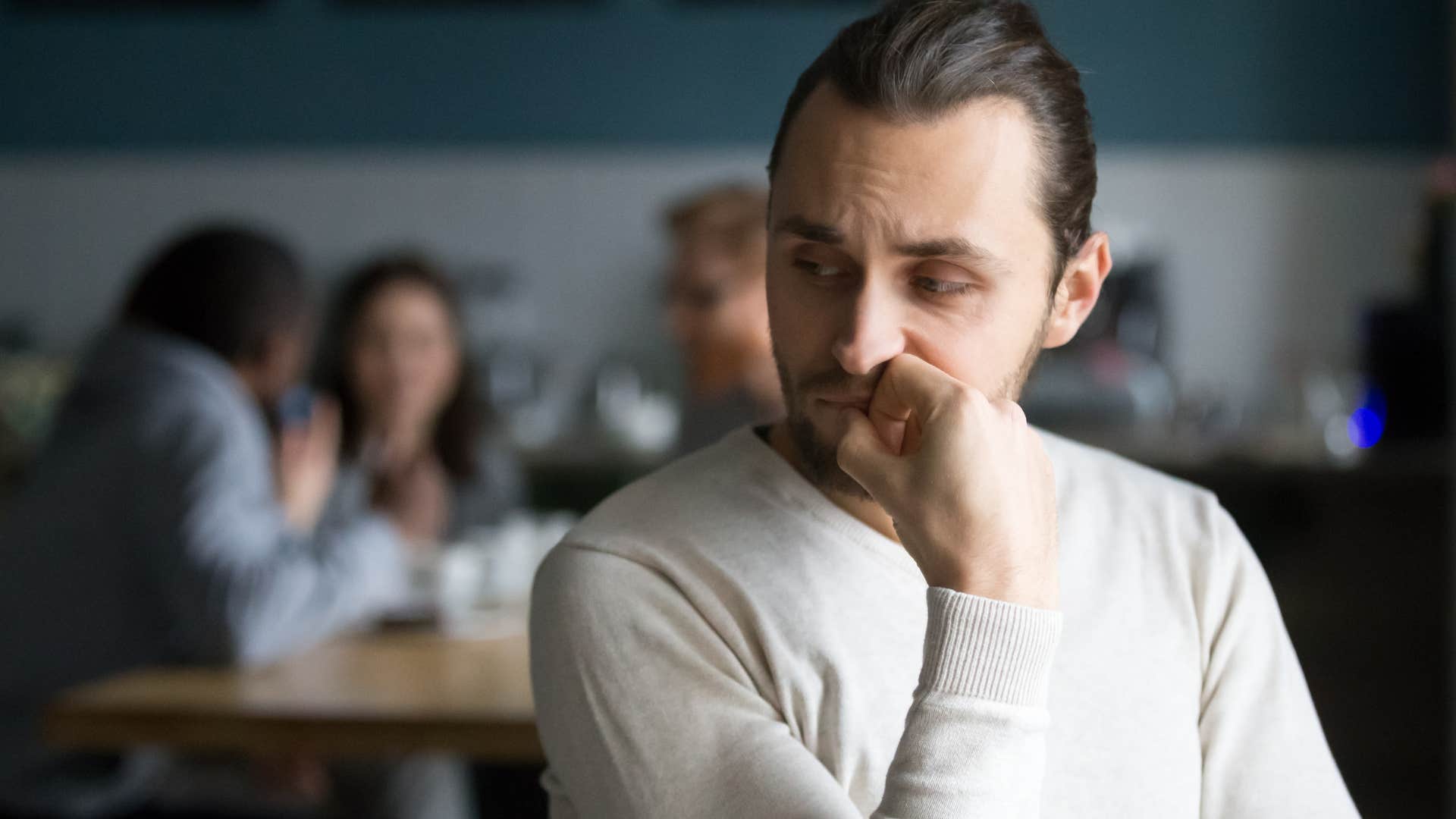 Upset man who has toxic friends sitting alone.
