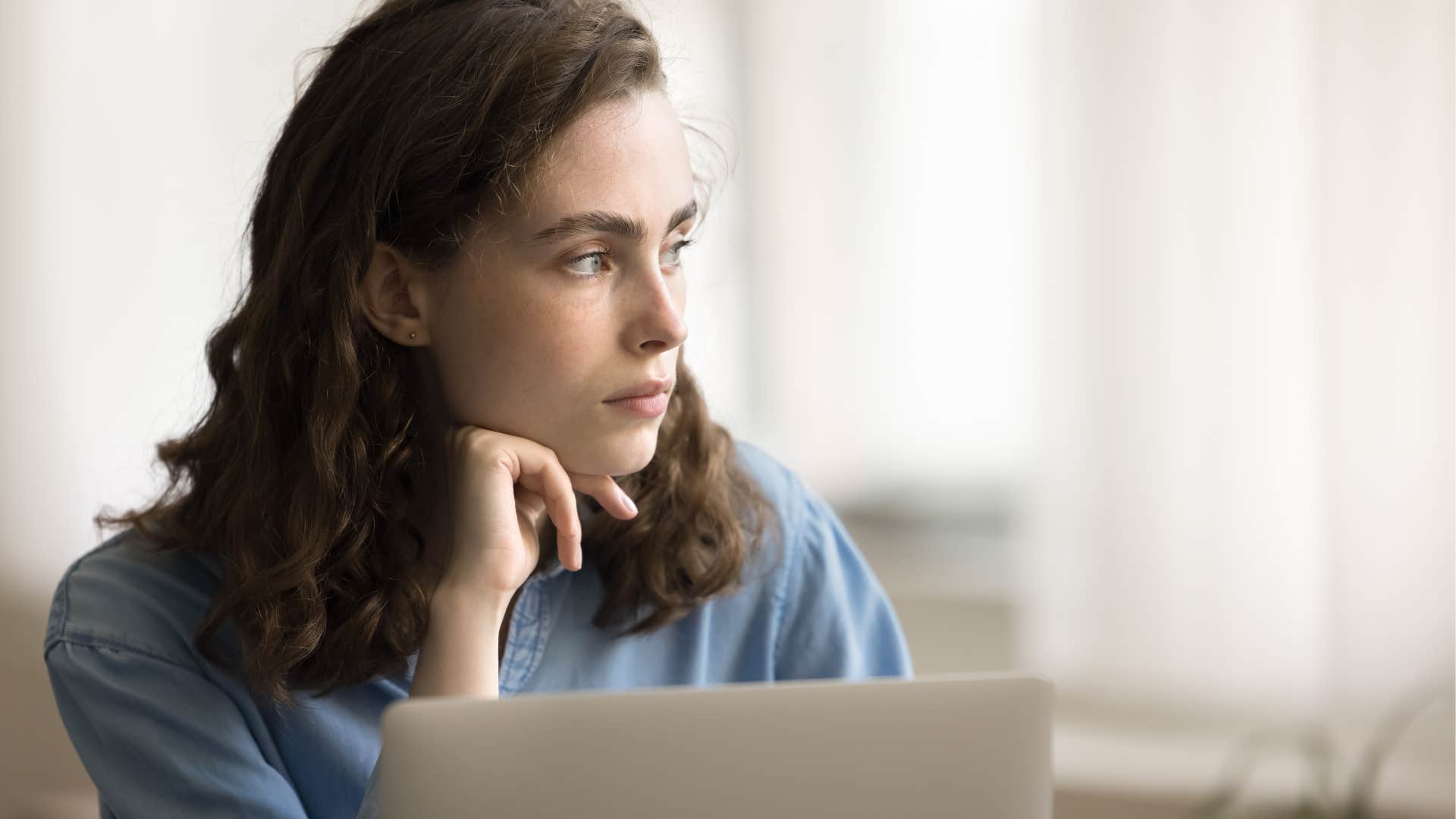 woman whose parents discouraged autonomy working at her desk