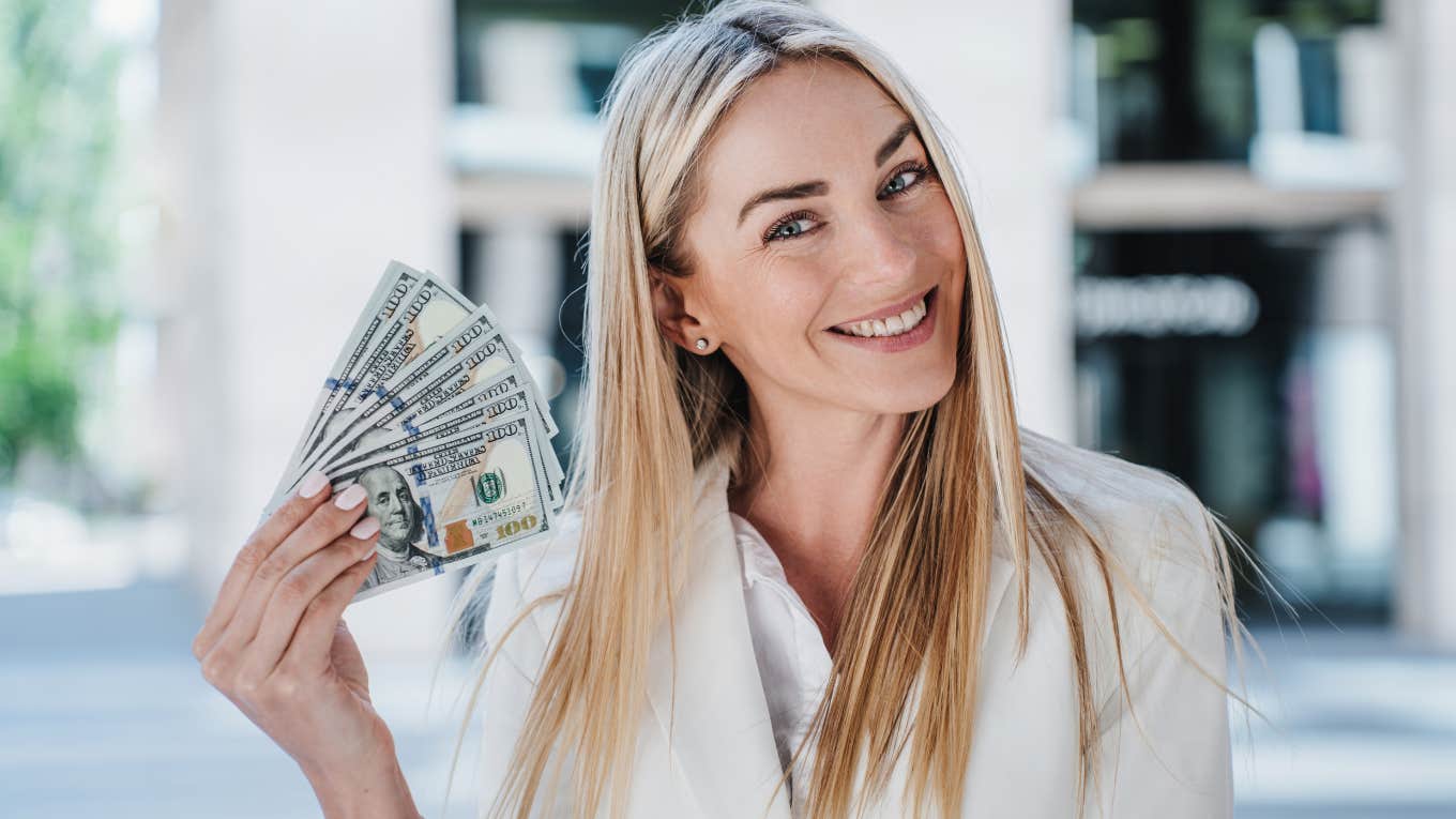 Signs From The Universe That You Are About To Receive Financial Abundance happy woman embracing financial abundance holding money