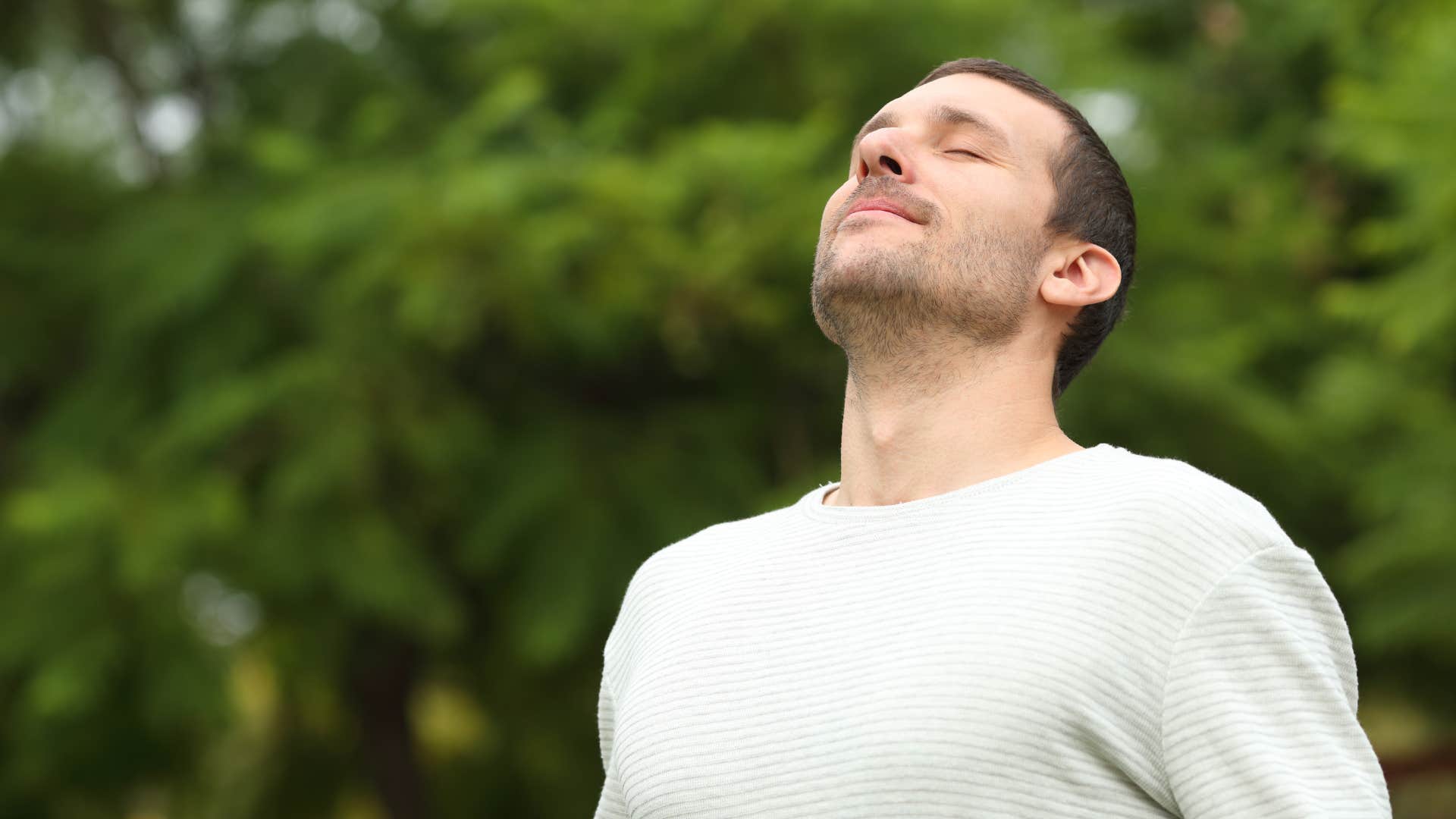 man investing in his personal growth as he deep breathes outside