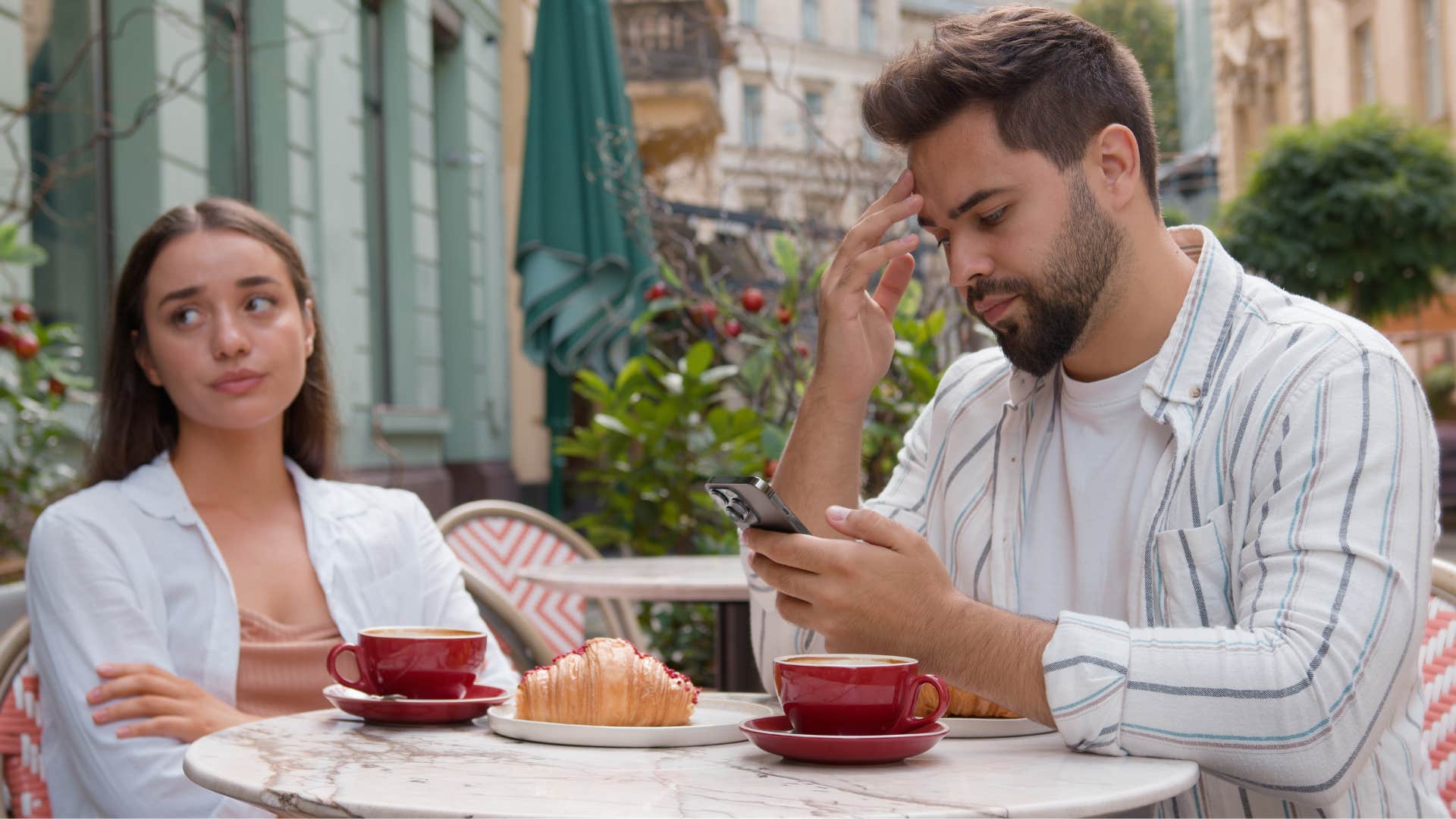 woman feels alone even when her partner is next to her at the cafe looking at his phone will ignoring her