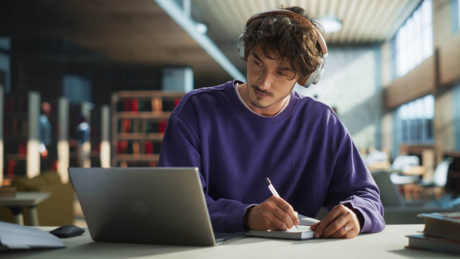 Man who knows that education is everything doing homework in a library.