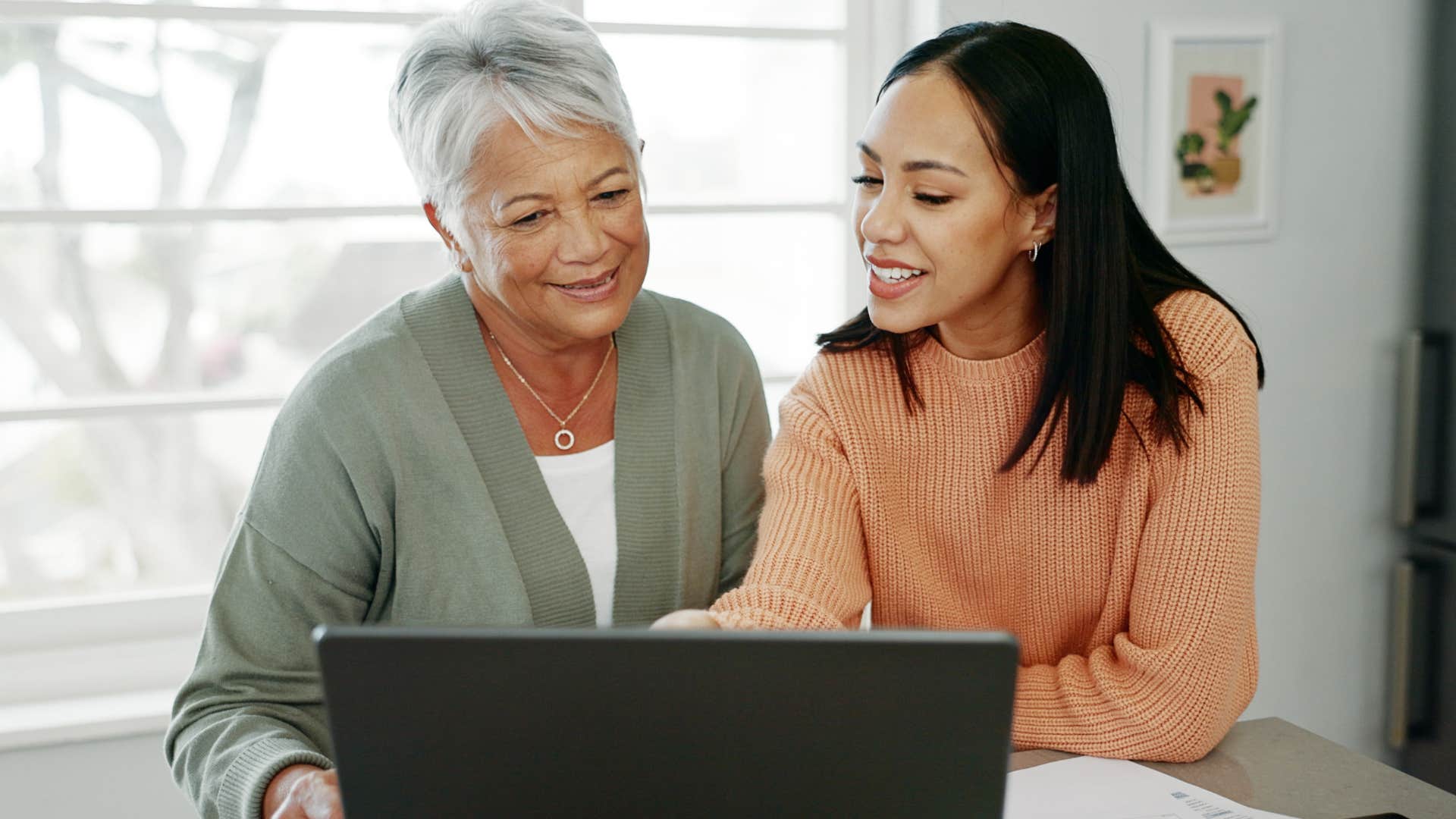 Woman who was the family translator looking at a laptop with her mother.