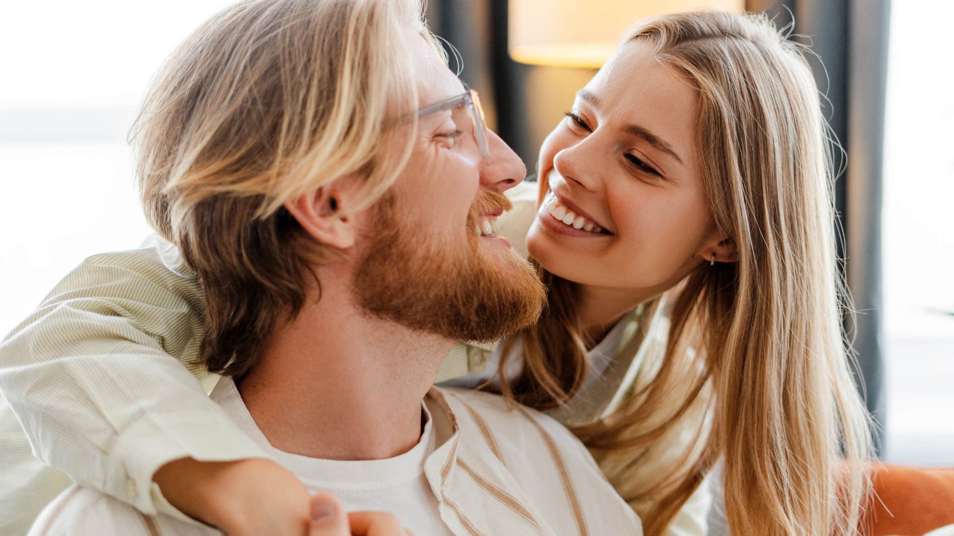 woman who asks for help when she needs it hugging her husband from behind