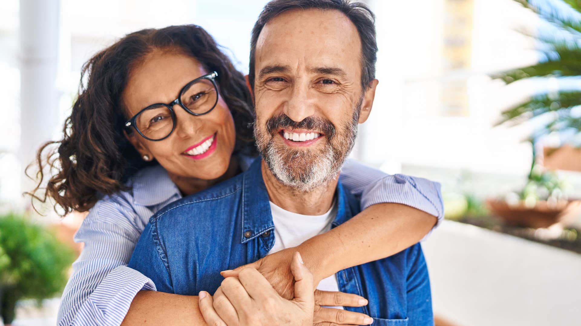 woman who talks highly of her partner hugging him from behind