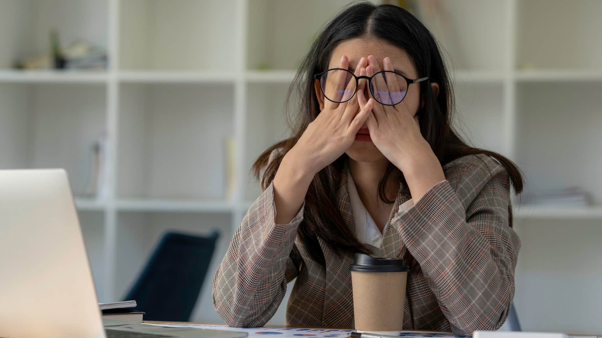 woman looking stressed in her office over too much clutter
