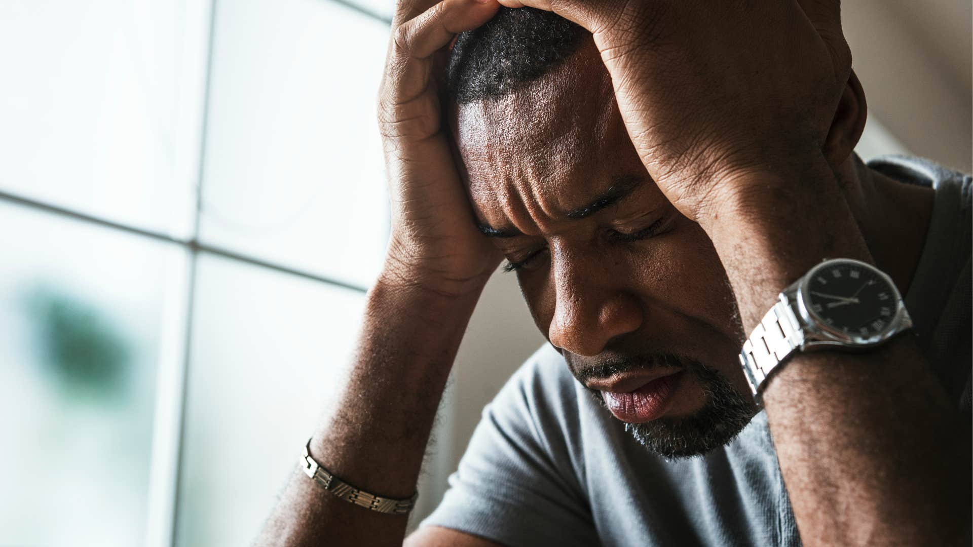 sad man feeling misunderstood holding his head in his hands