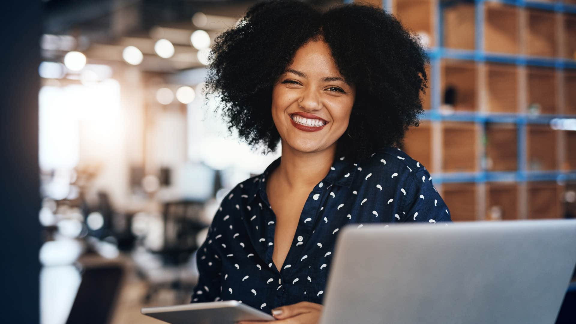 woman who dresses authentically smiling while working