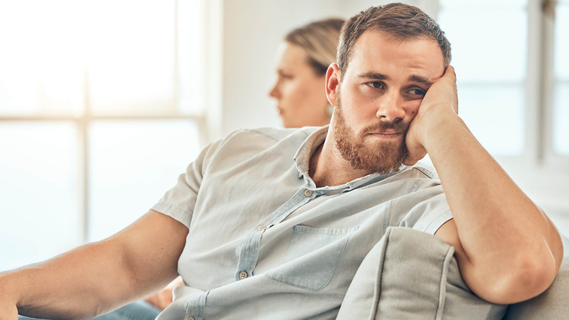 upset man turned away from his wife who embarrasses him in public