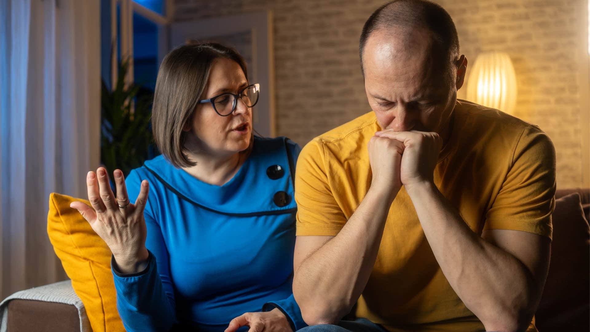 husband sitting next to his upset wife who regularly talks over him
