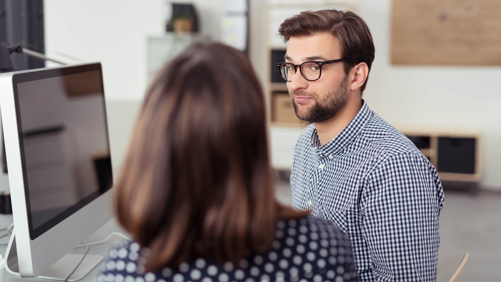 man giving short responses to his co-worker to avoid conversation