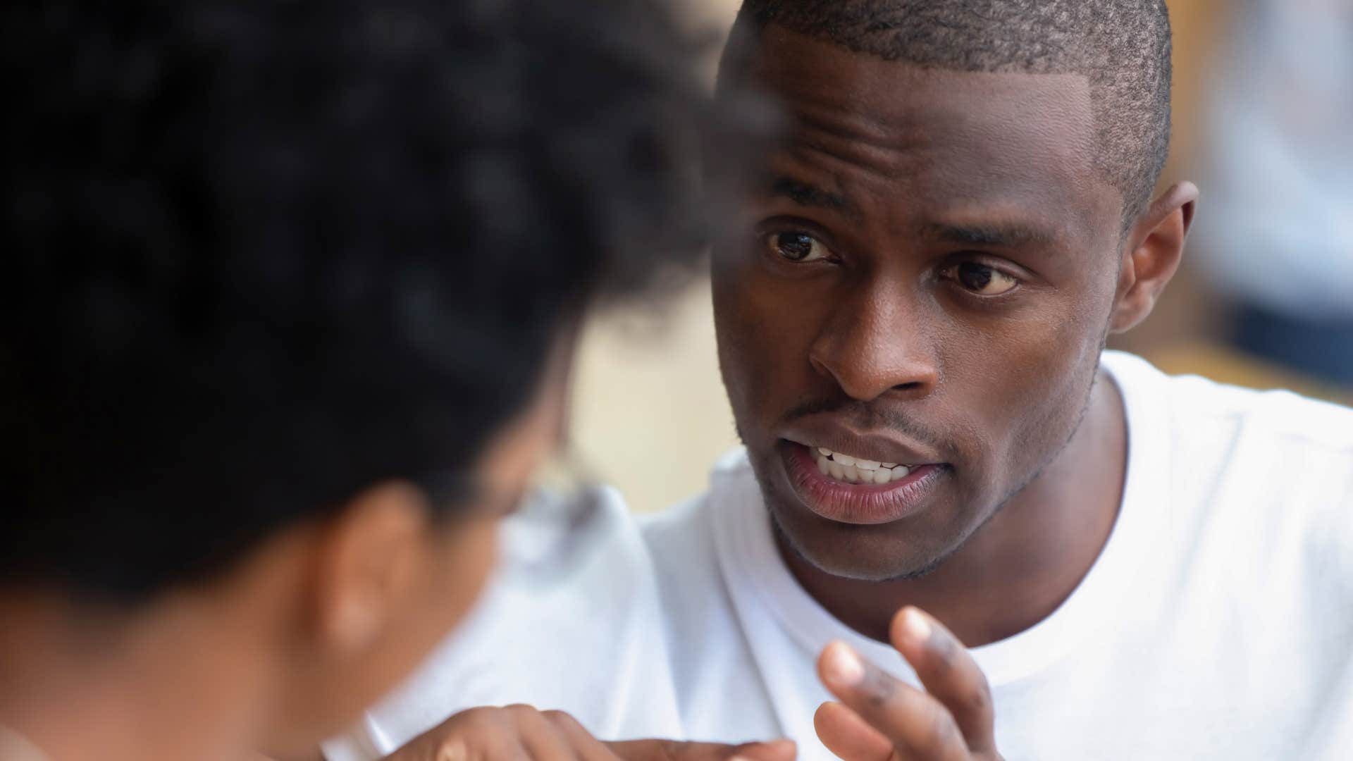 Man talking to a friend who can downplay their success.