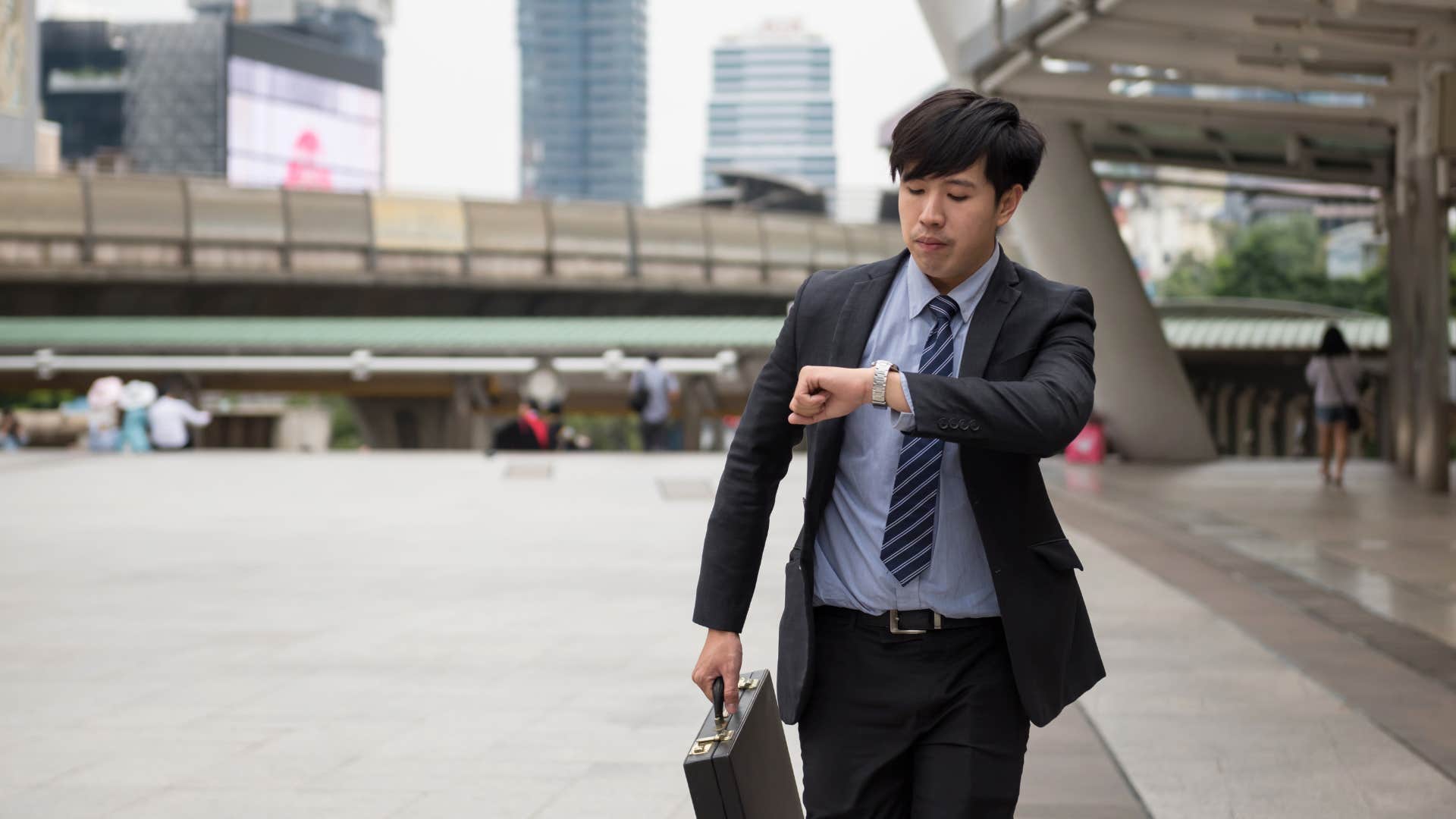 man who is running late looking at his watch