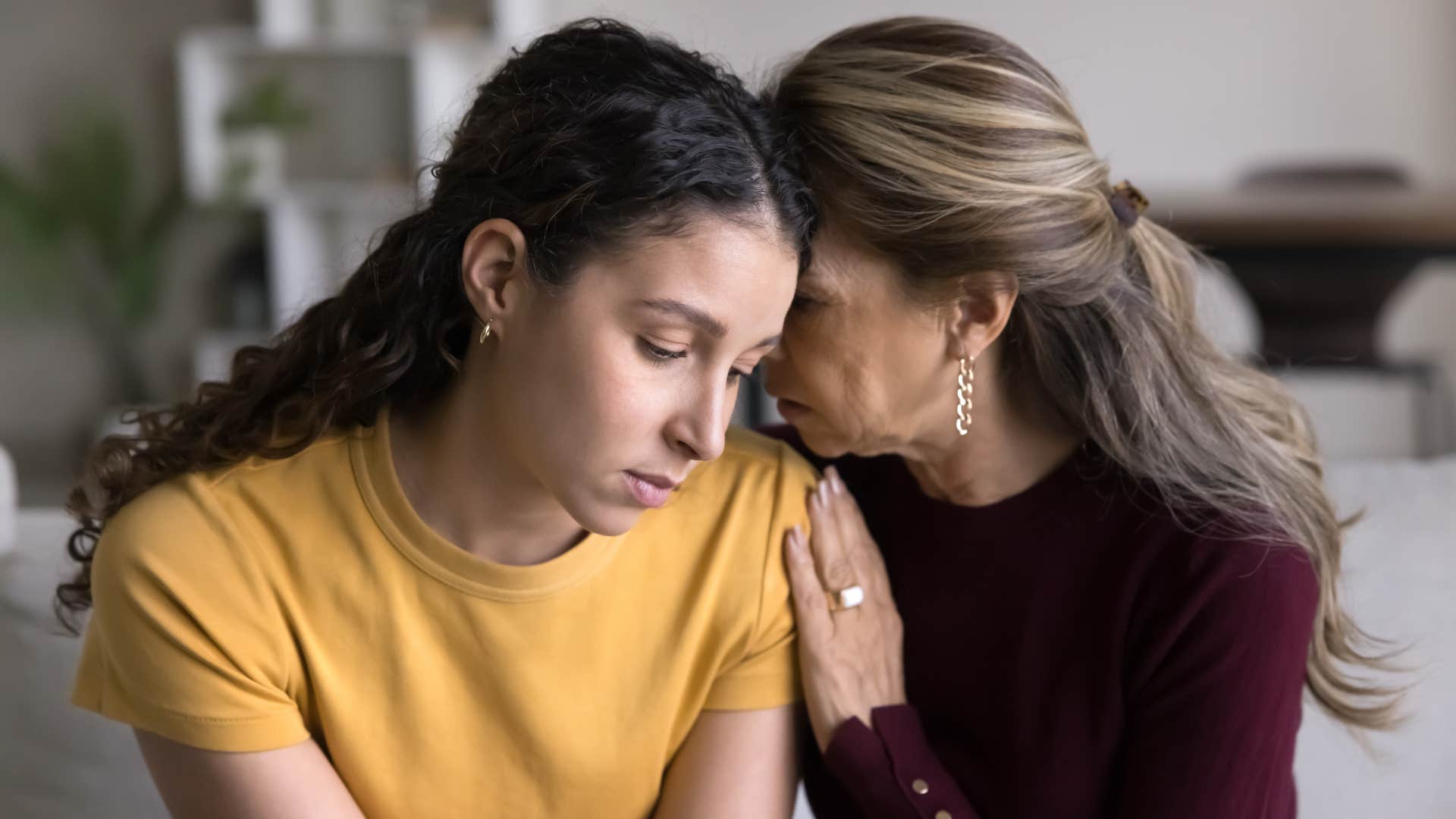 a mother tries to comfort her daughter because she appears fine but looks like she lacks joy