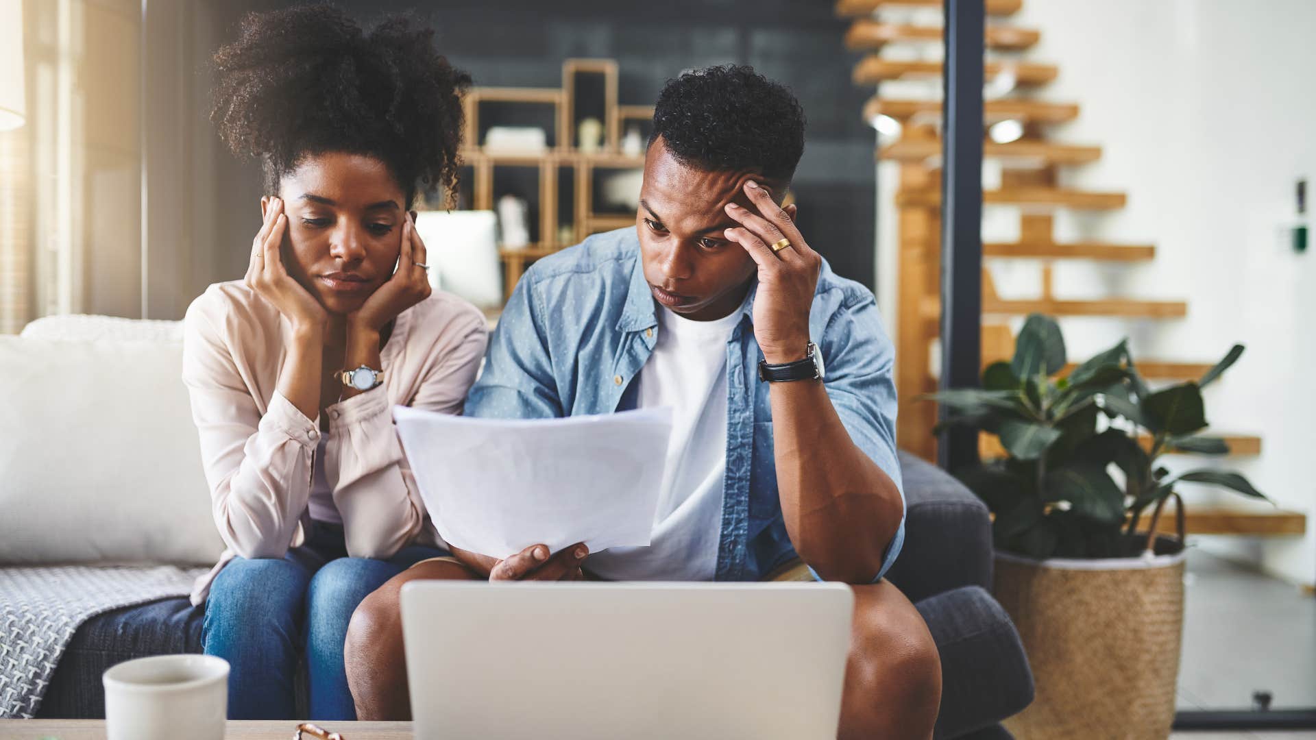 couple looking at paper in disbelief as they're expected to pay for extremely expensive childcare