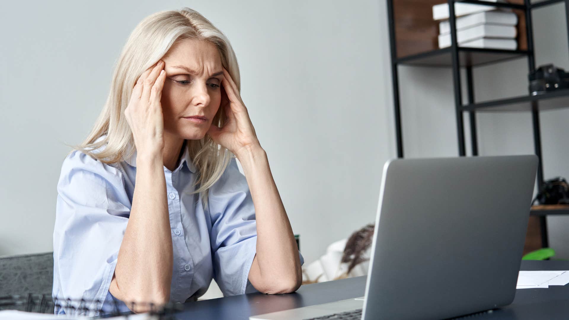 stressed out employee sitting in front of laptop