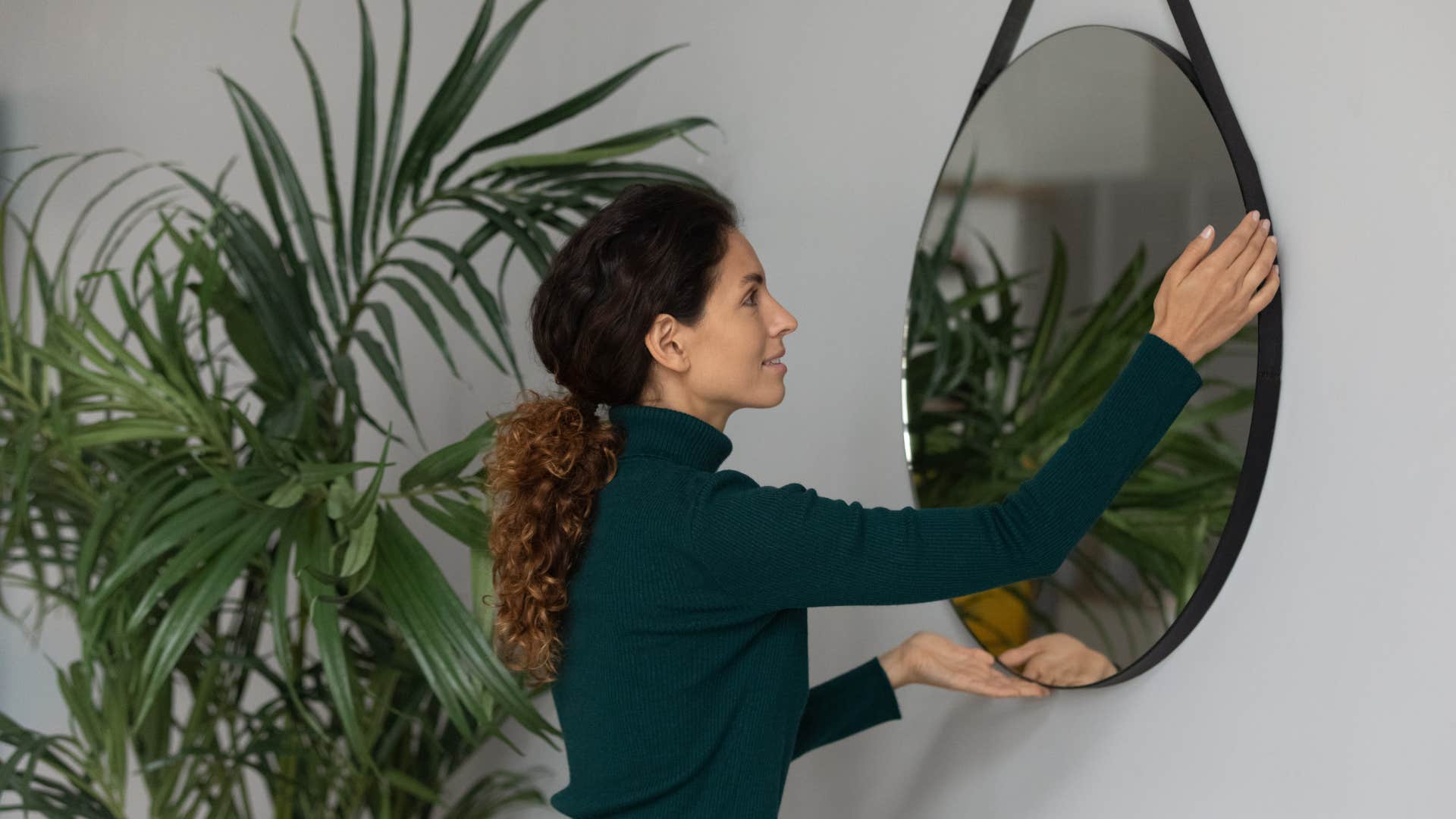 woman hanging brand new mirror