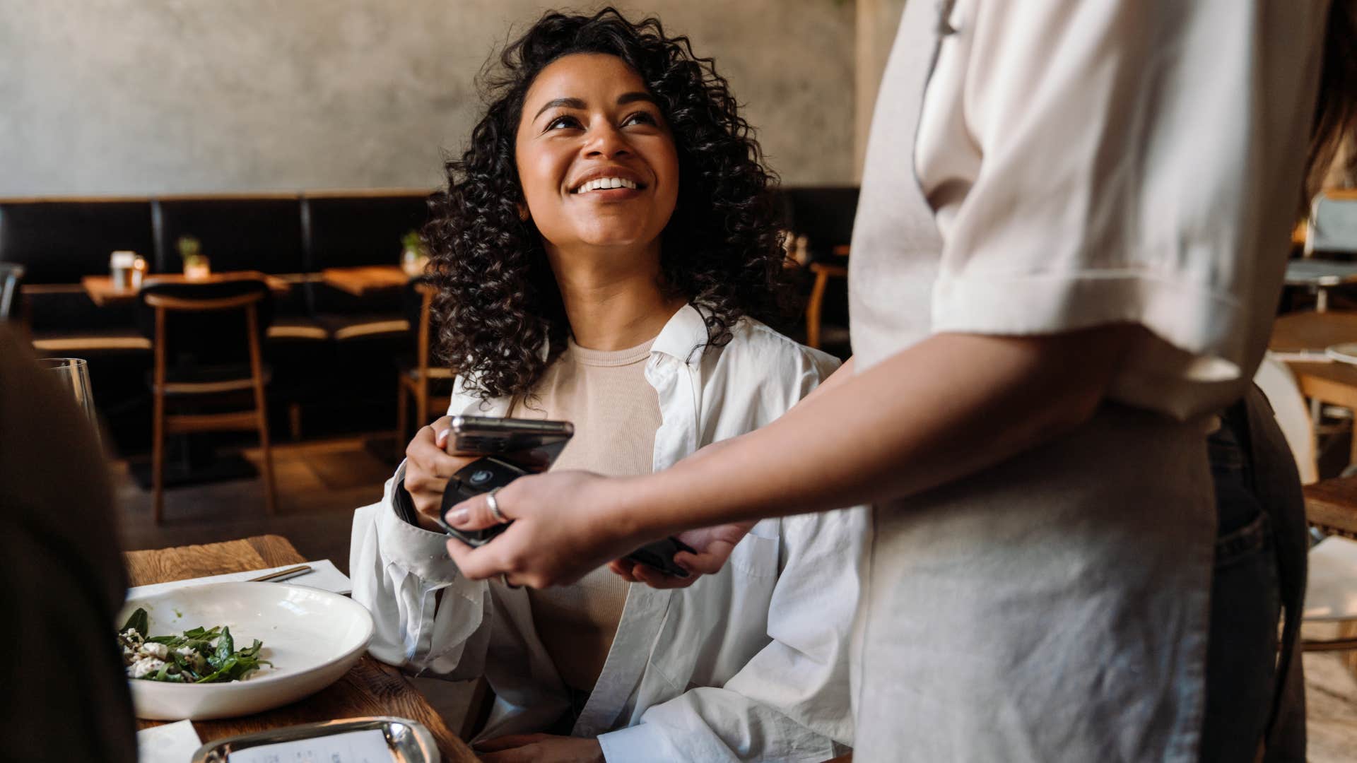 Woman calculating exactly how much to tip at a restaurant.