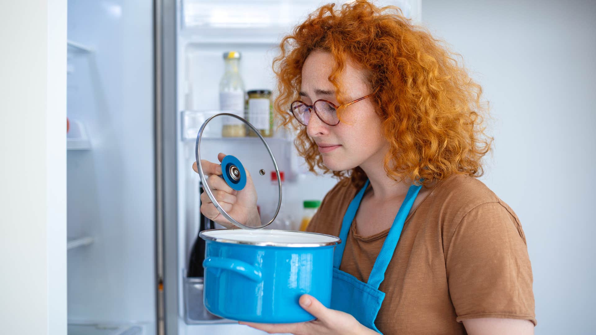 Woman smelling and offering expired food to guests.