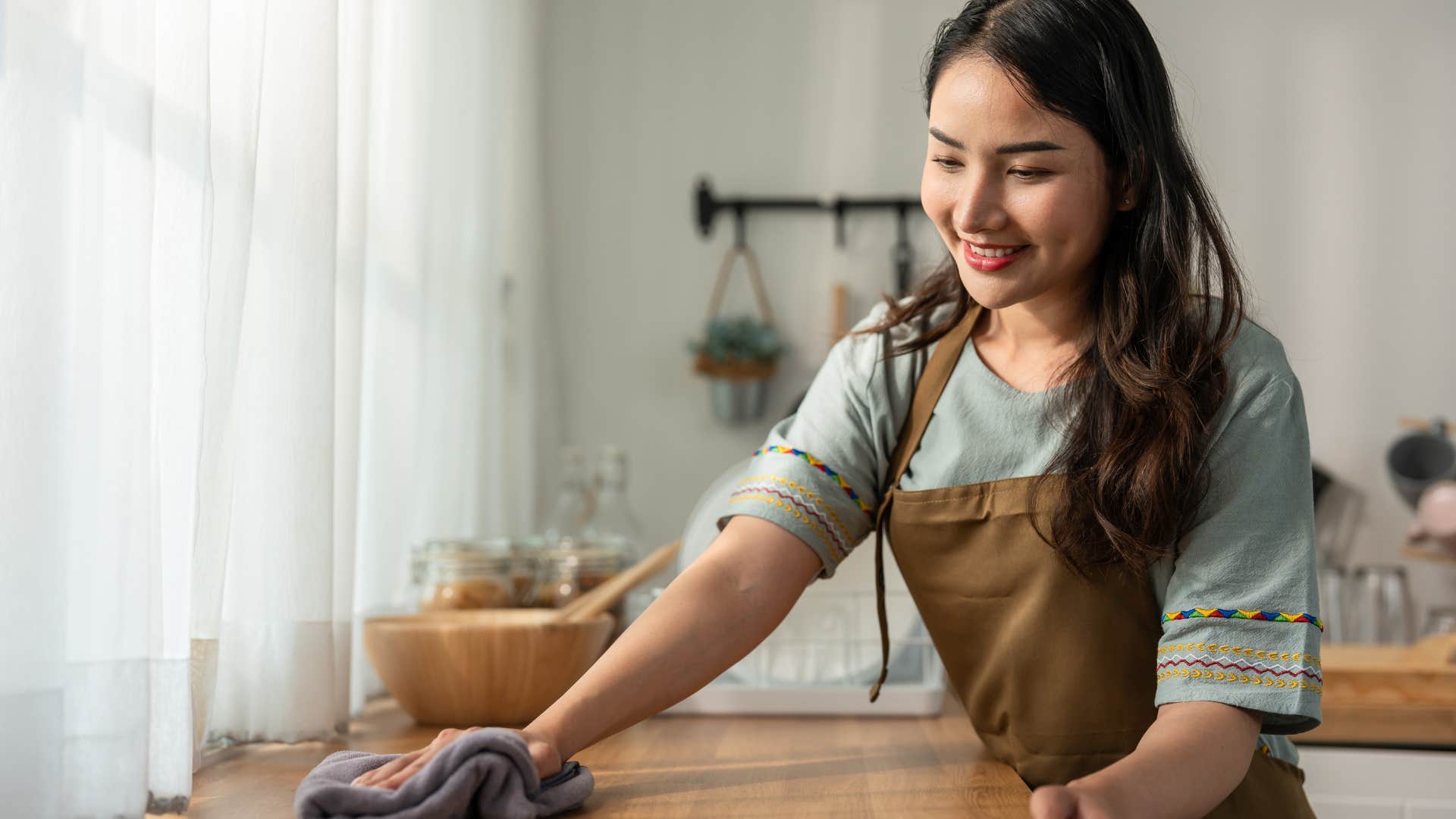 woman using cloths and rags to clean her kitchen