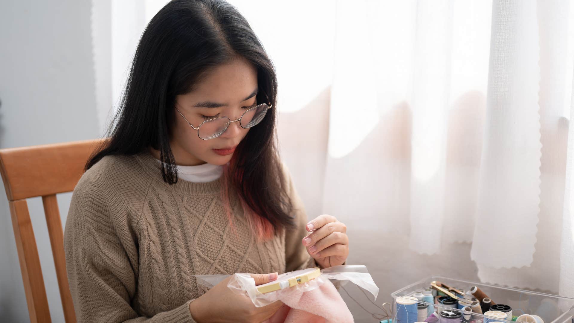 woman using a sewing kit at home