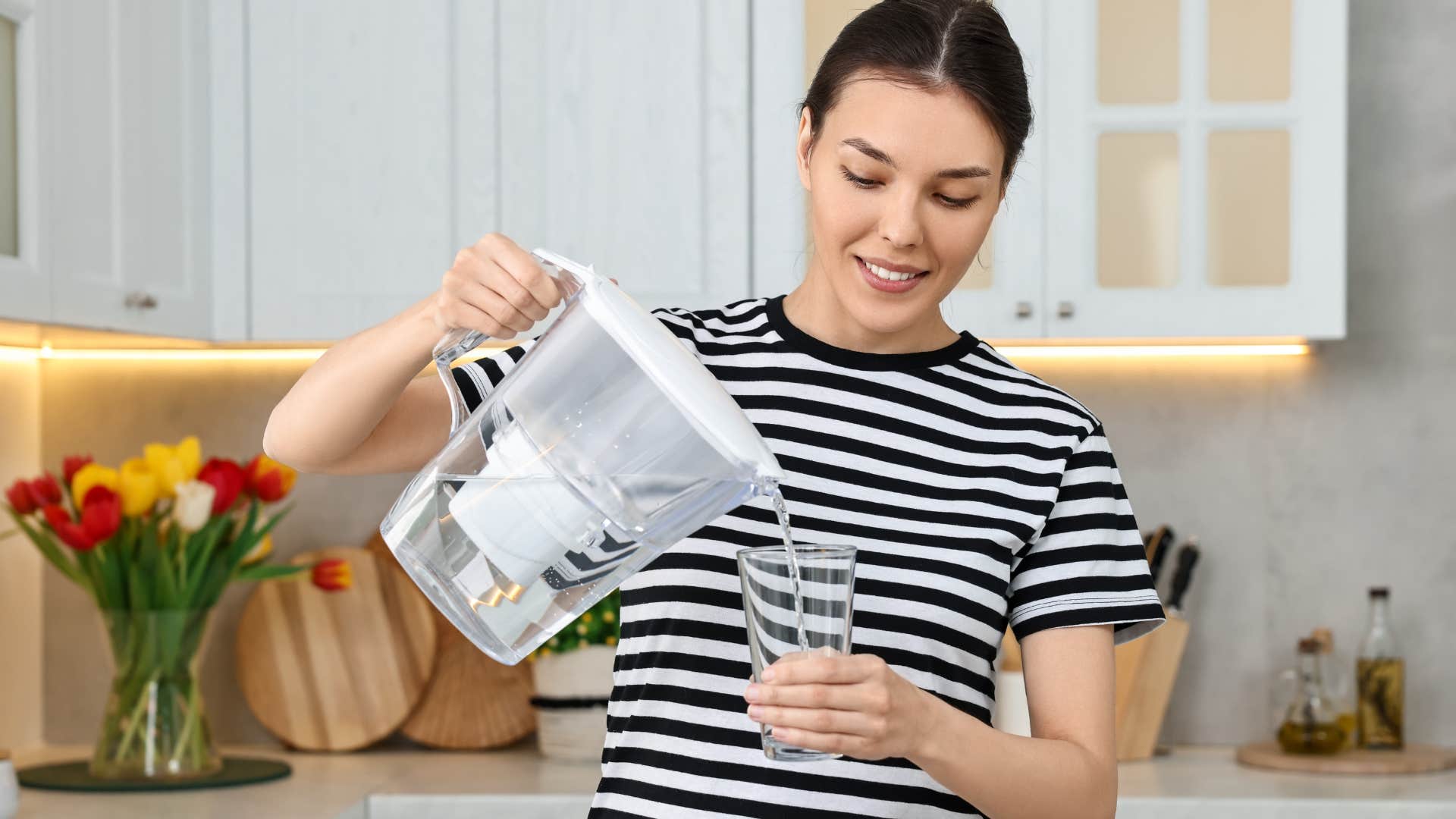 woman using a water filter in her kitchen at home