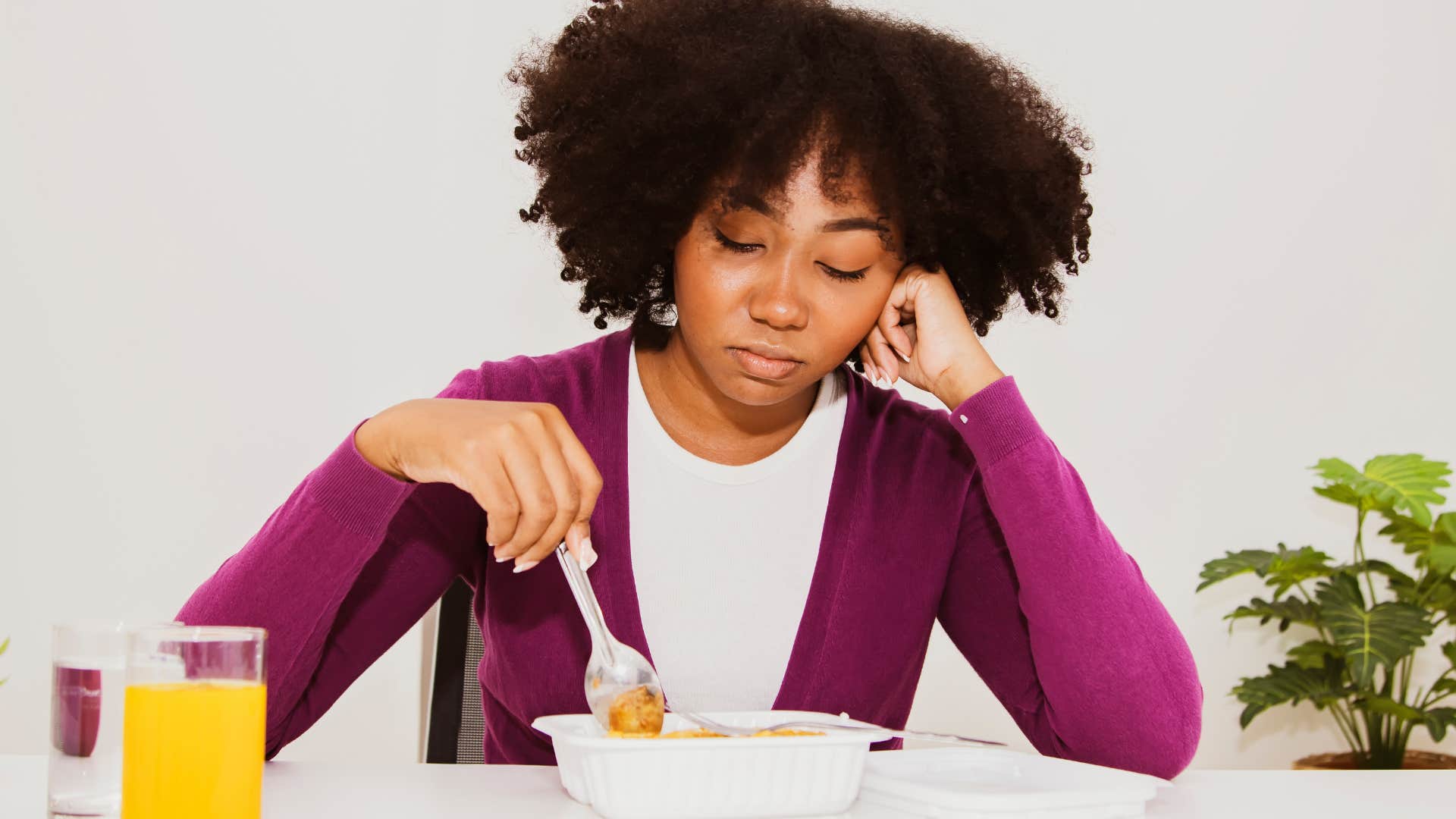 woman eating food out of plastic container