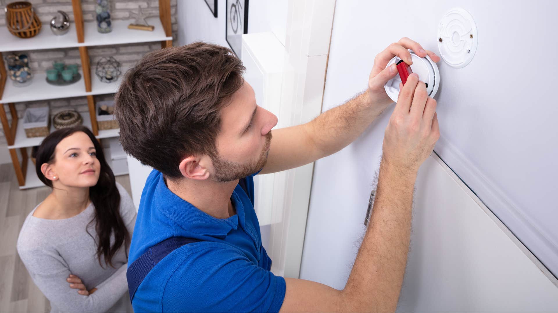 frugal couple changing batteries on smoke detector