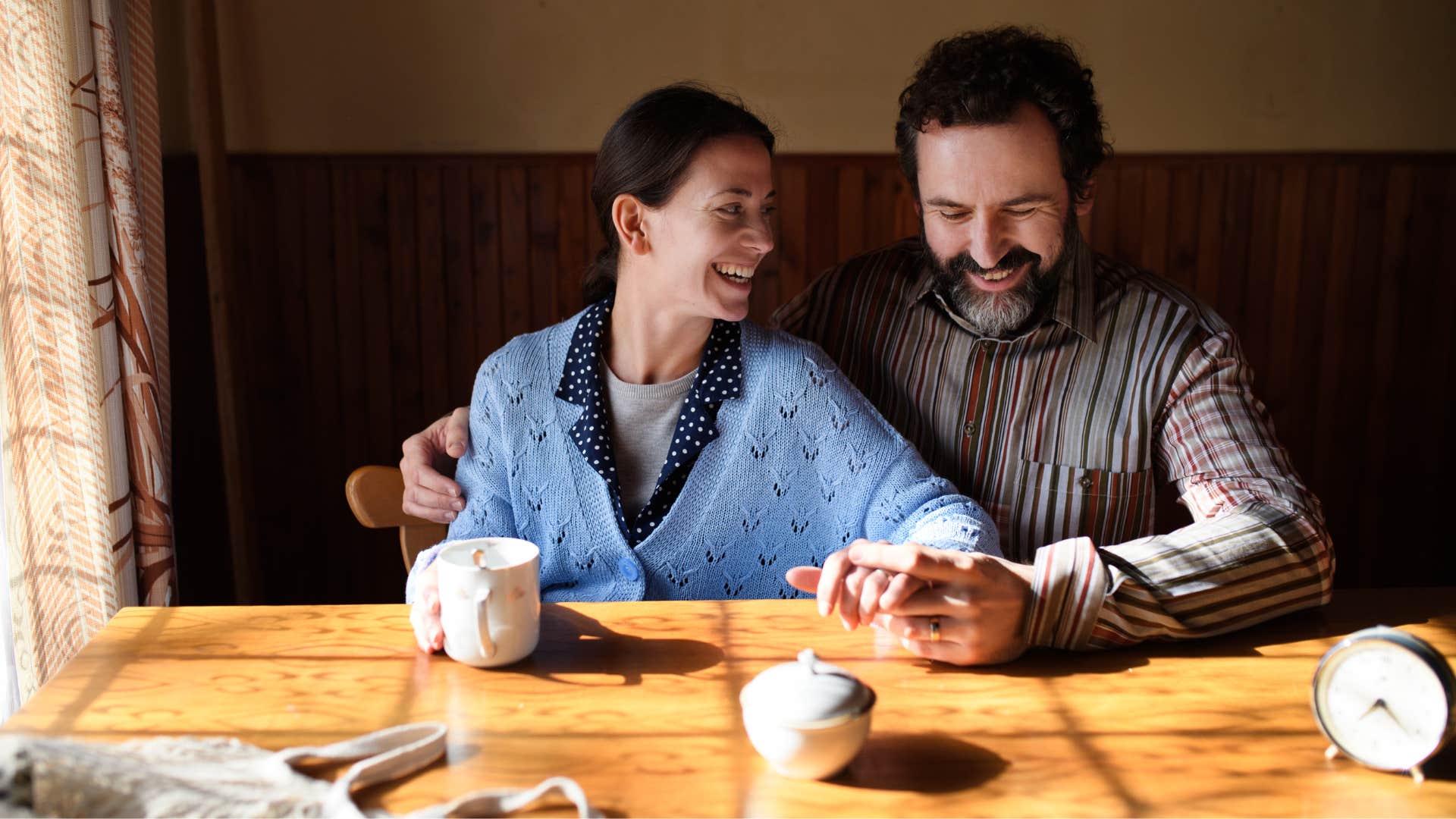 couple in humble clothing chatting and smiling as they avoid debt like the plague and lives below means