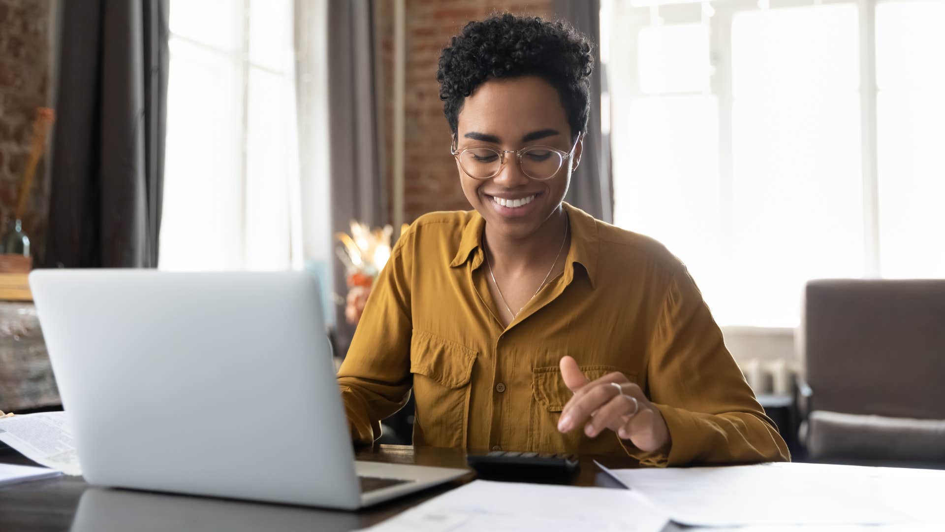 woman in brown shirt and glasses sticking to budget no matter how tempting it may be to overspend