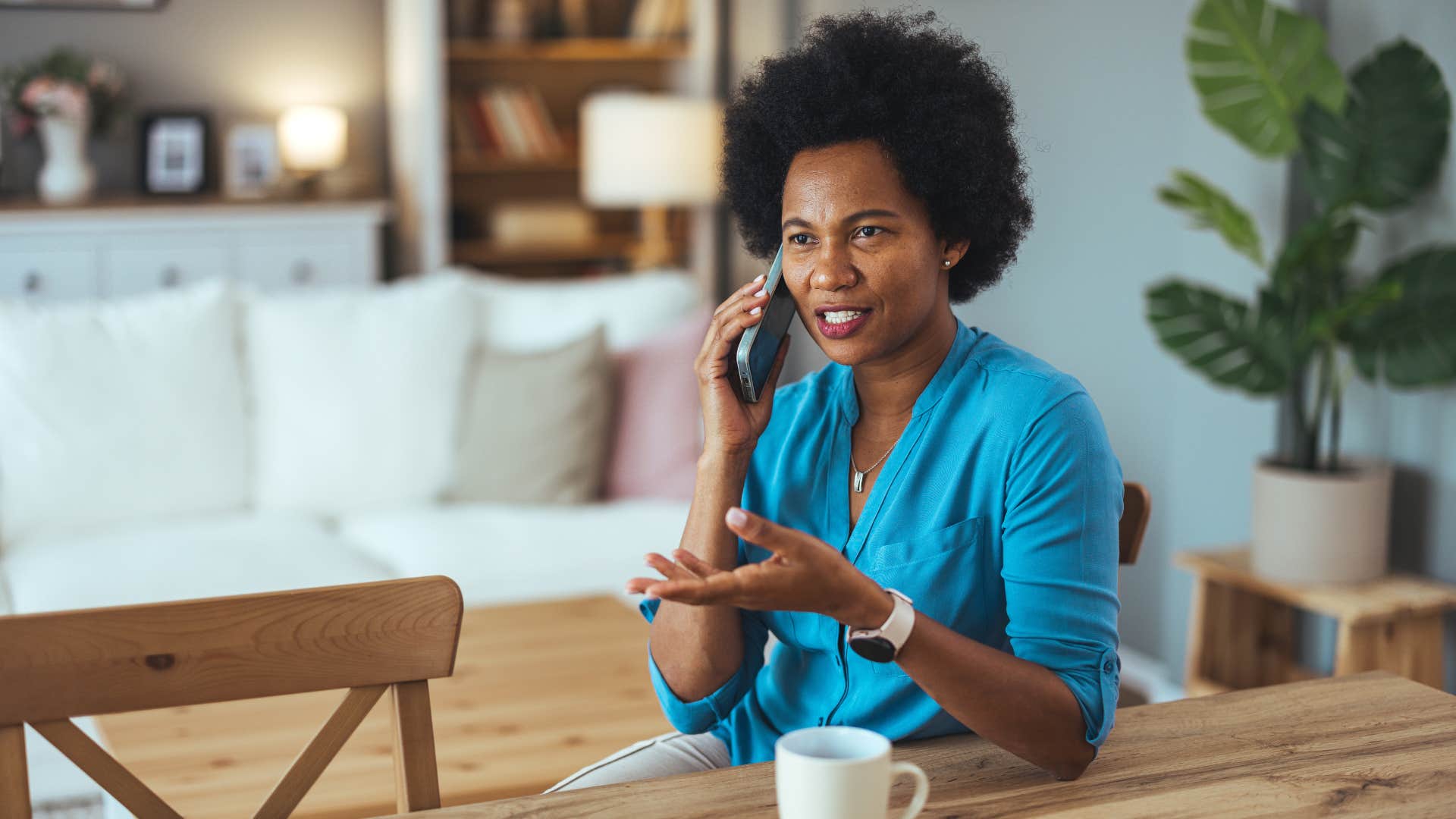 woman in blue shirt on the phone being unafraid to say no to plans that cost too much