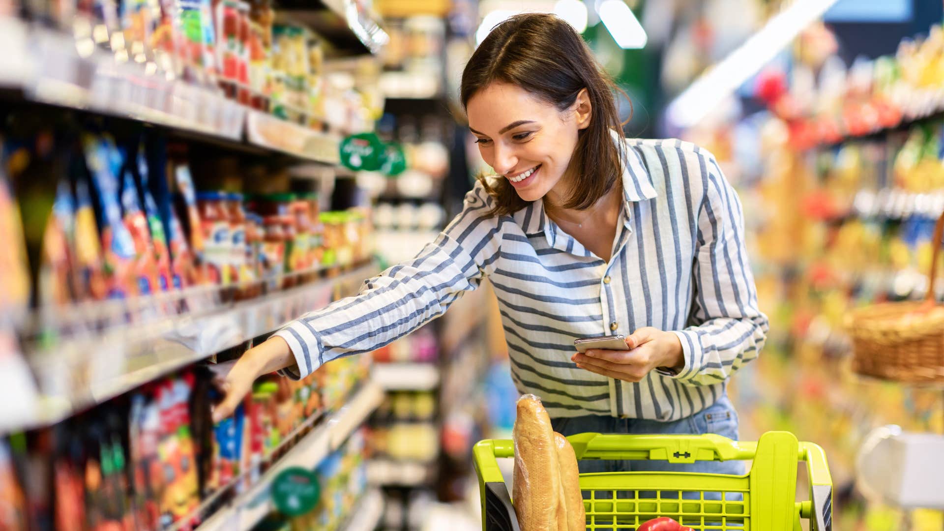 woman in stripped shirt ignoring sales or discounts as she grabs food off shelf