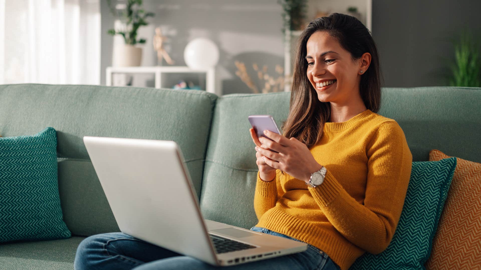 woman in orange shirt sitting on the couch as she surfs through her many subscriptions
