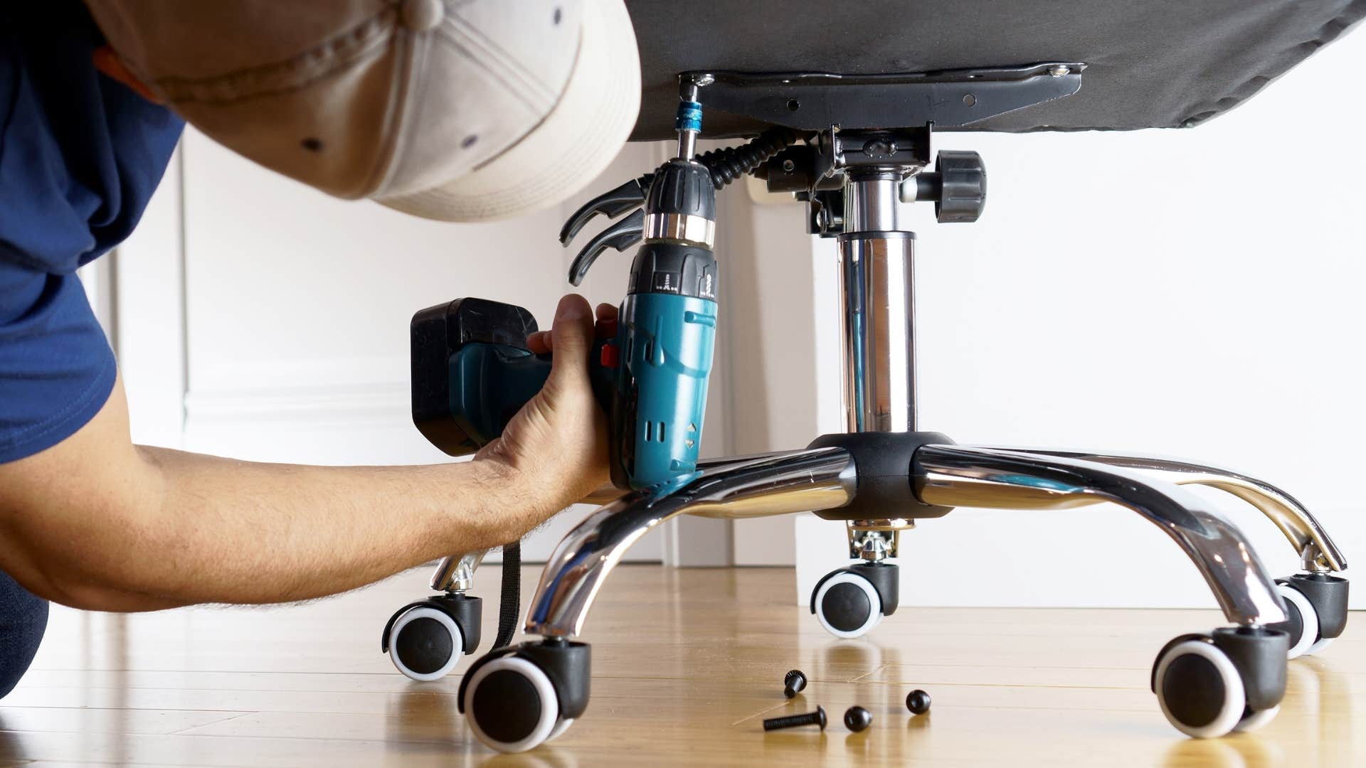 gen z man trying to fix his desk chair