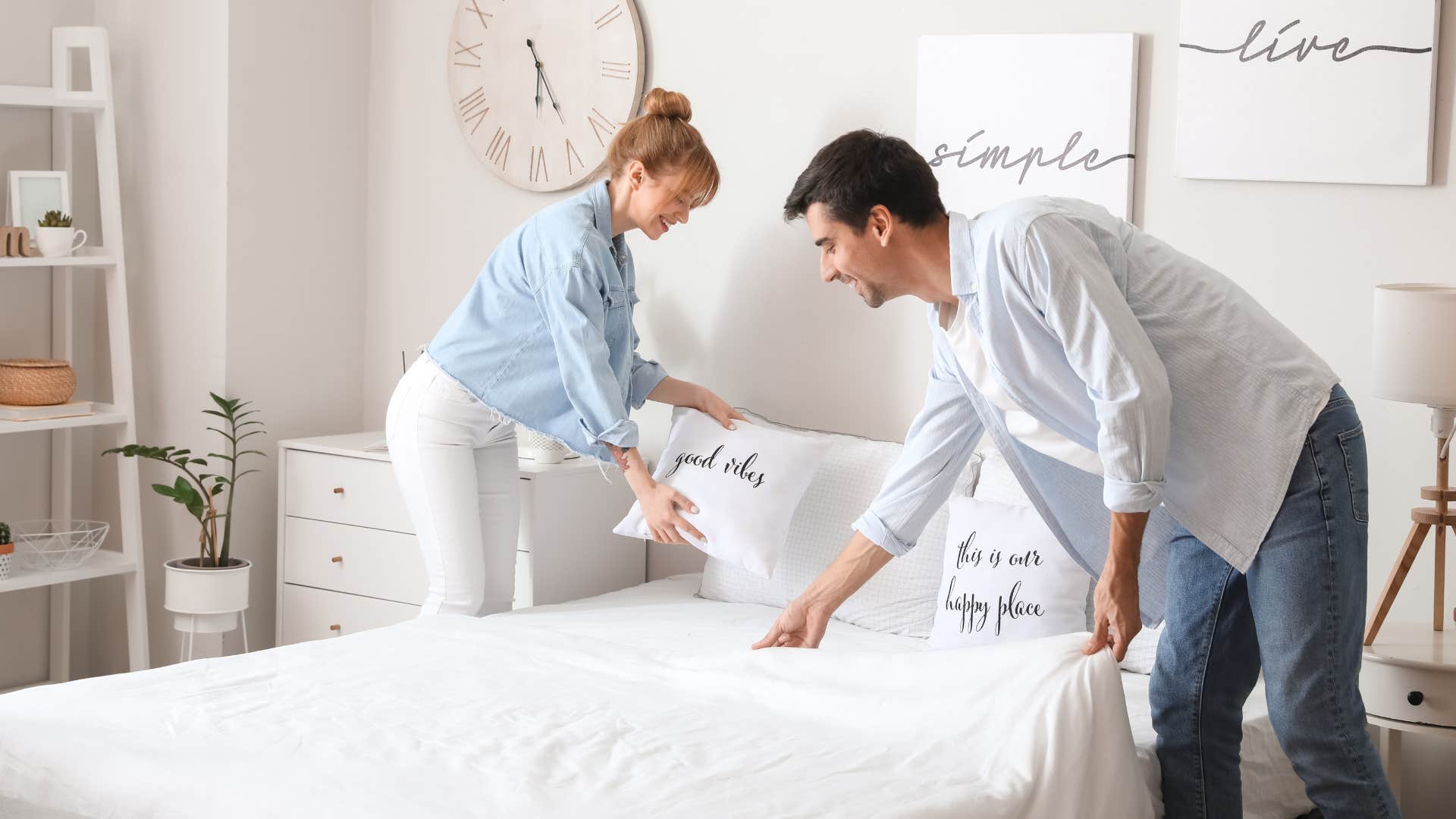 happy couple making the bed before 9 AM