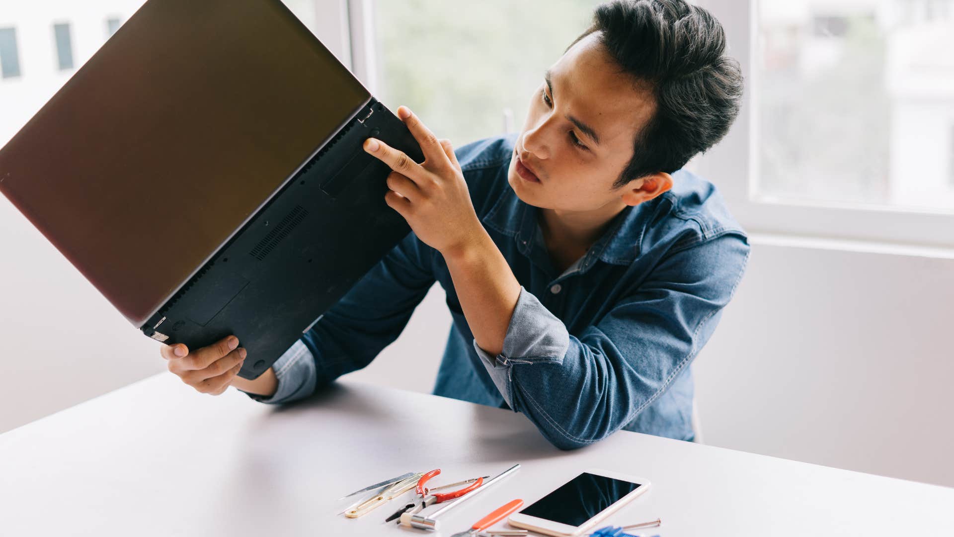 man trying to fix broken laptop