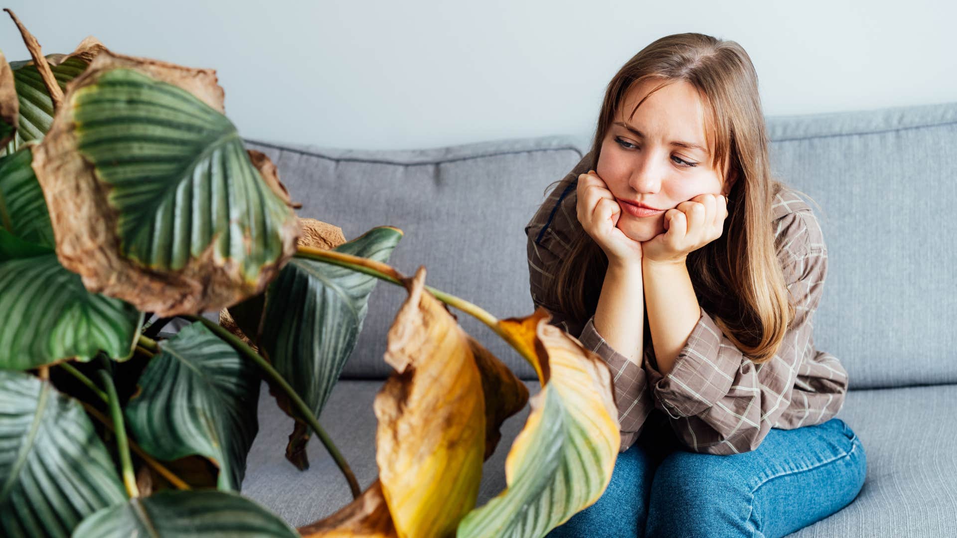 woman glaring at her dead plant thats stopping her money flow