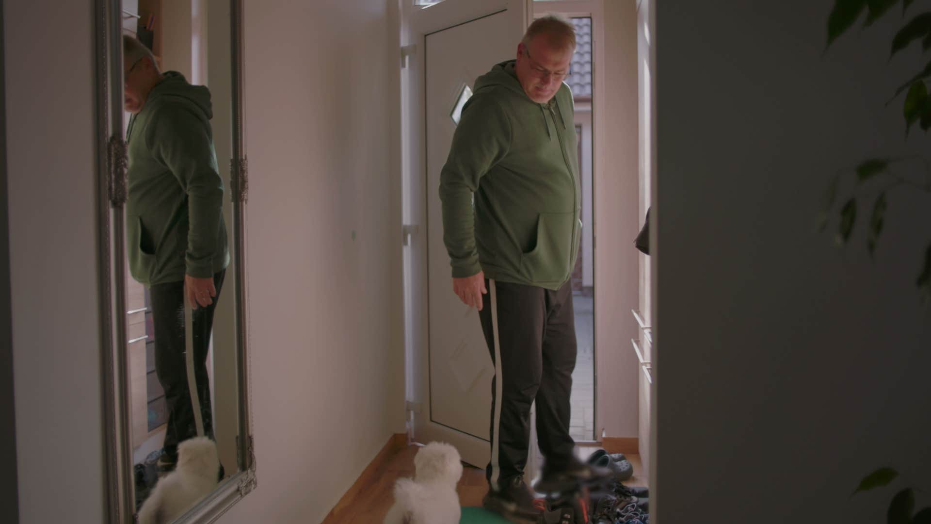 man opening door that has mirror in front of it for bad feng shui