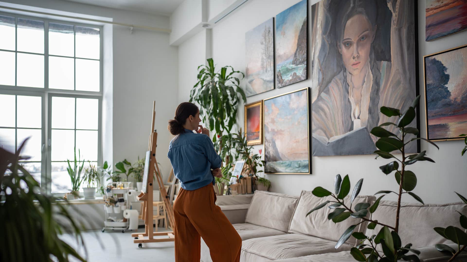 woman looking at the sad artwork on her walls