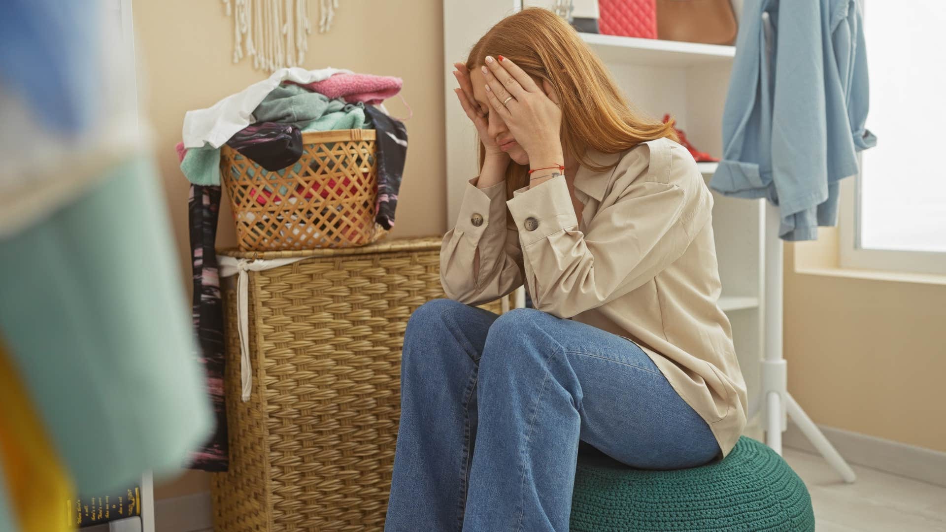 woman overwhelmed with overflowing laundry piles