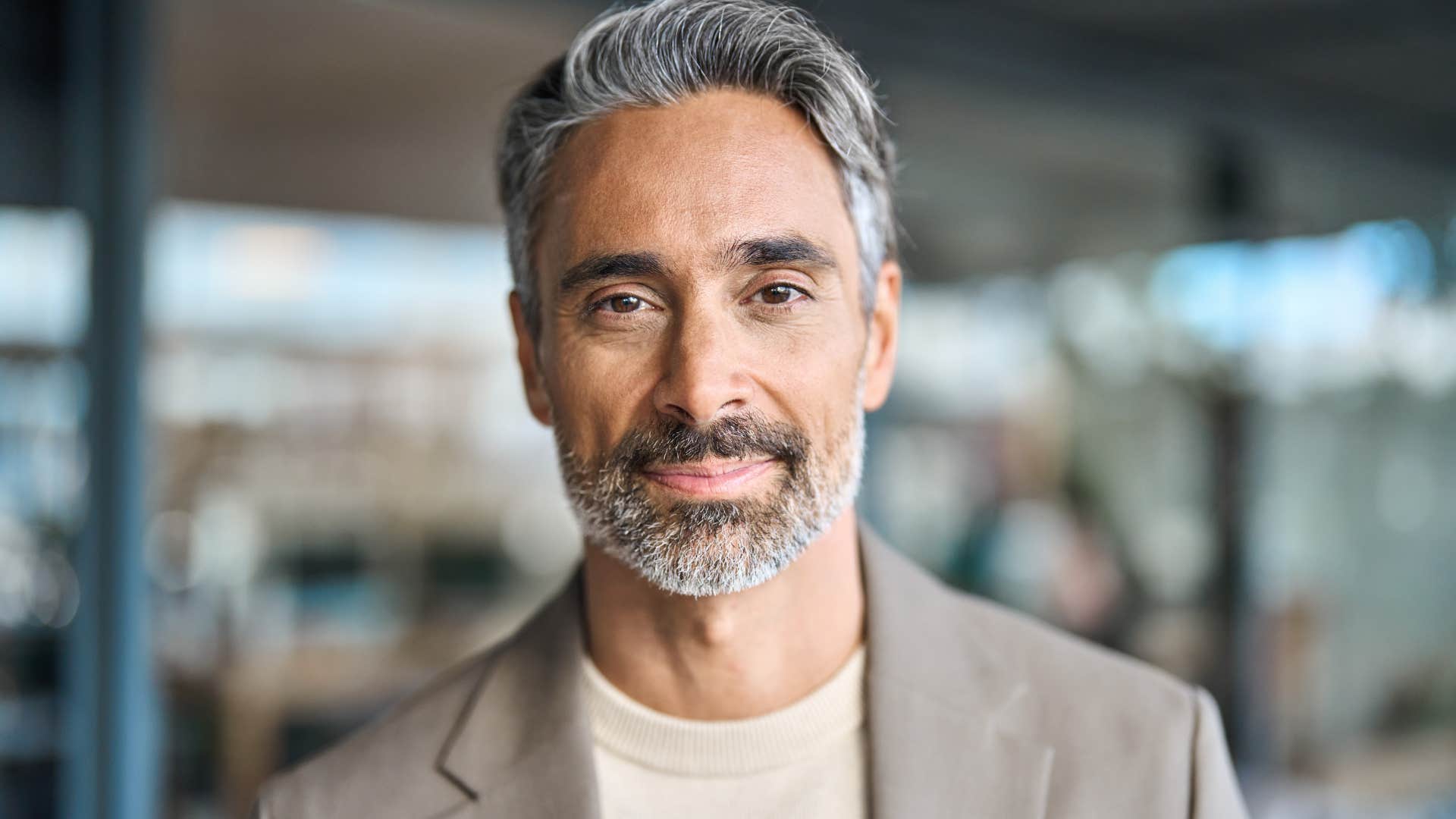 Man who doesn't care about competition smiling in an office.