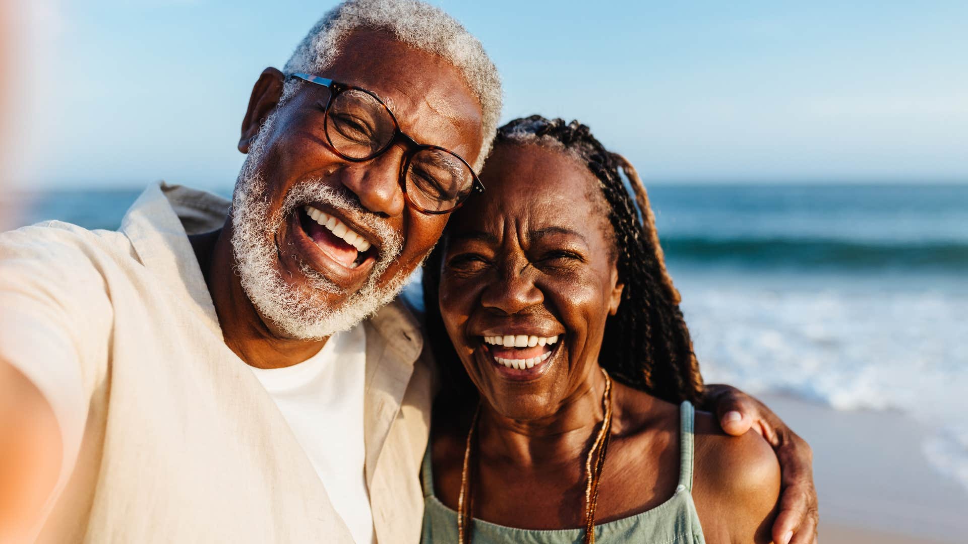 Man who's not forcing relationships hugging his partner on a beach.