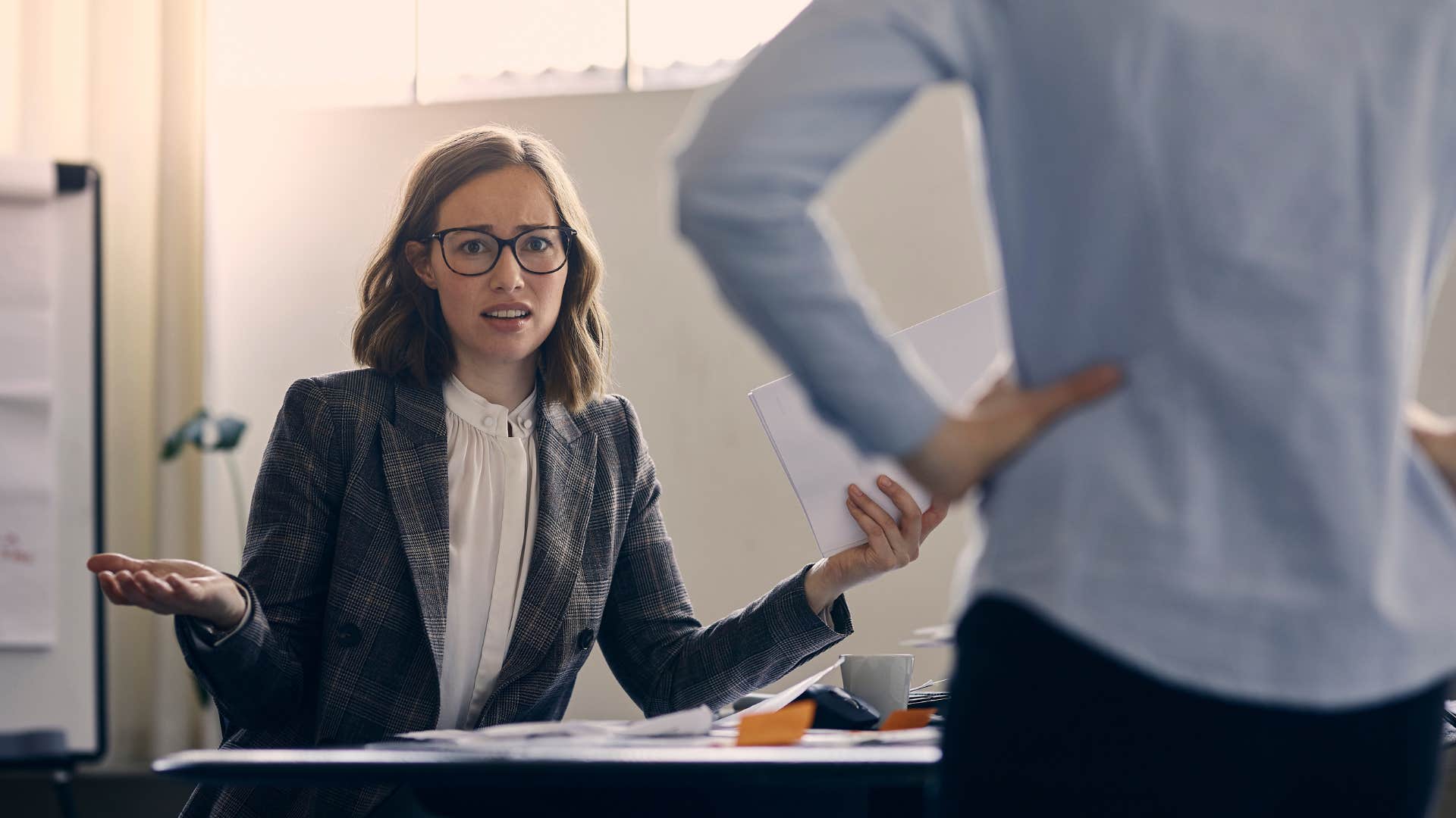 a gen z woman questions her boss over a project not making sense
