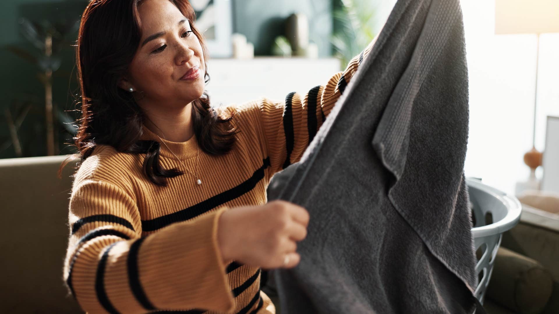 a gen z woman looks at the clothes she got from the thrift store