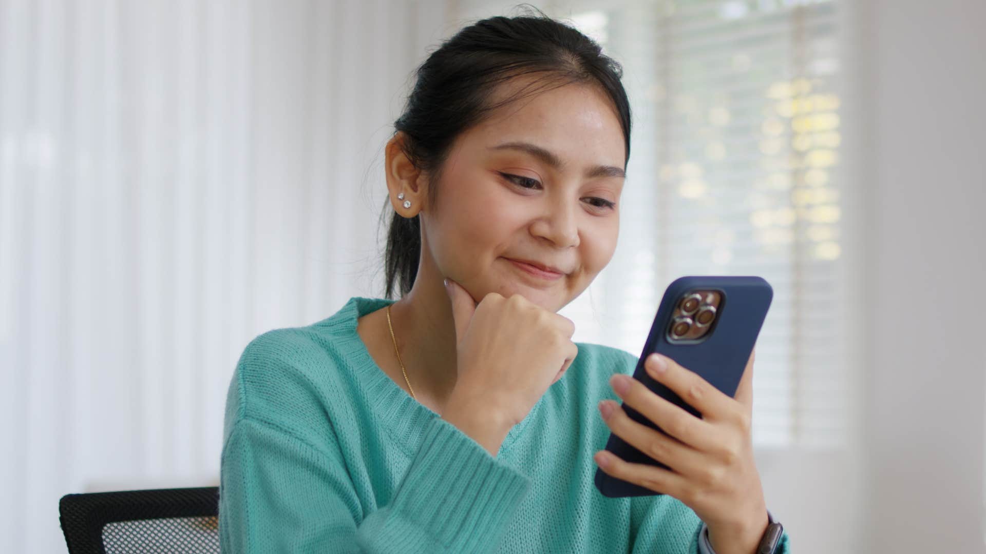 smiling woman rewatching her own social media content
