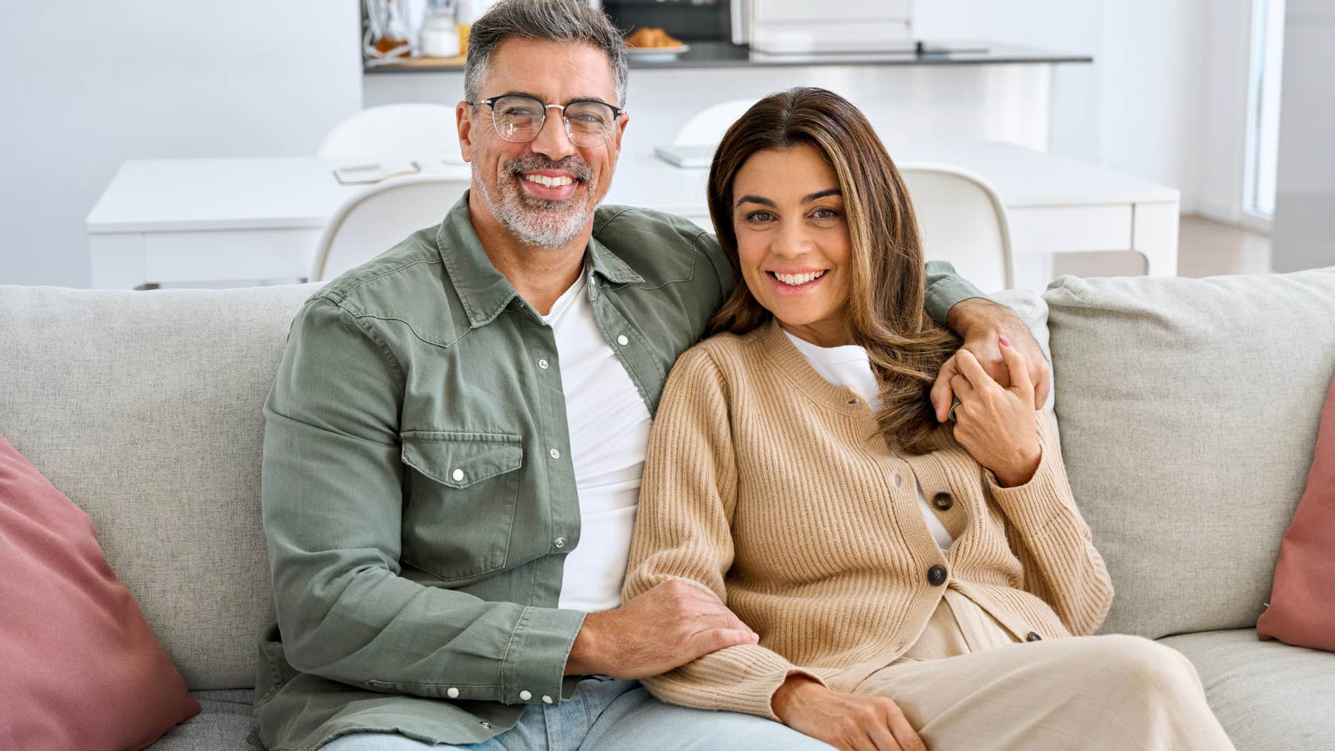 couple smiling on their couch with matching decor