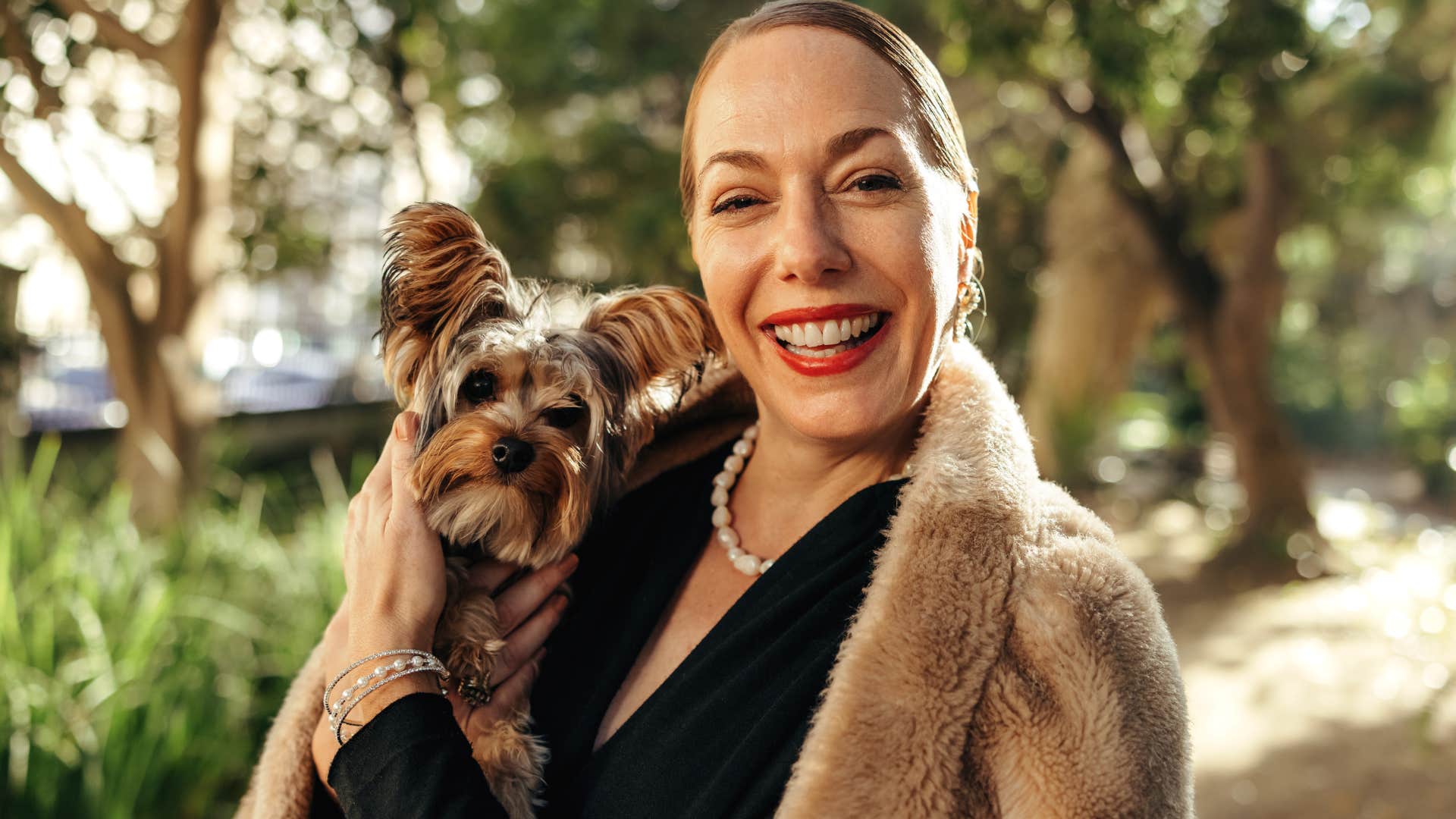 wealthy woman holding her well-groomed pet